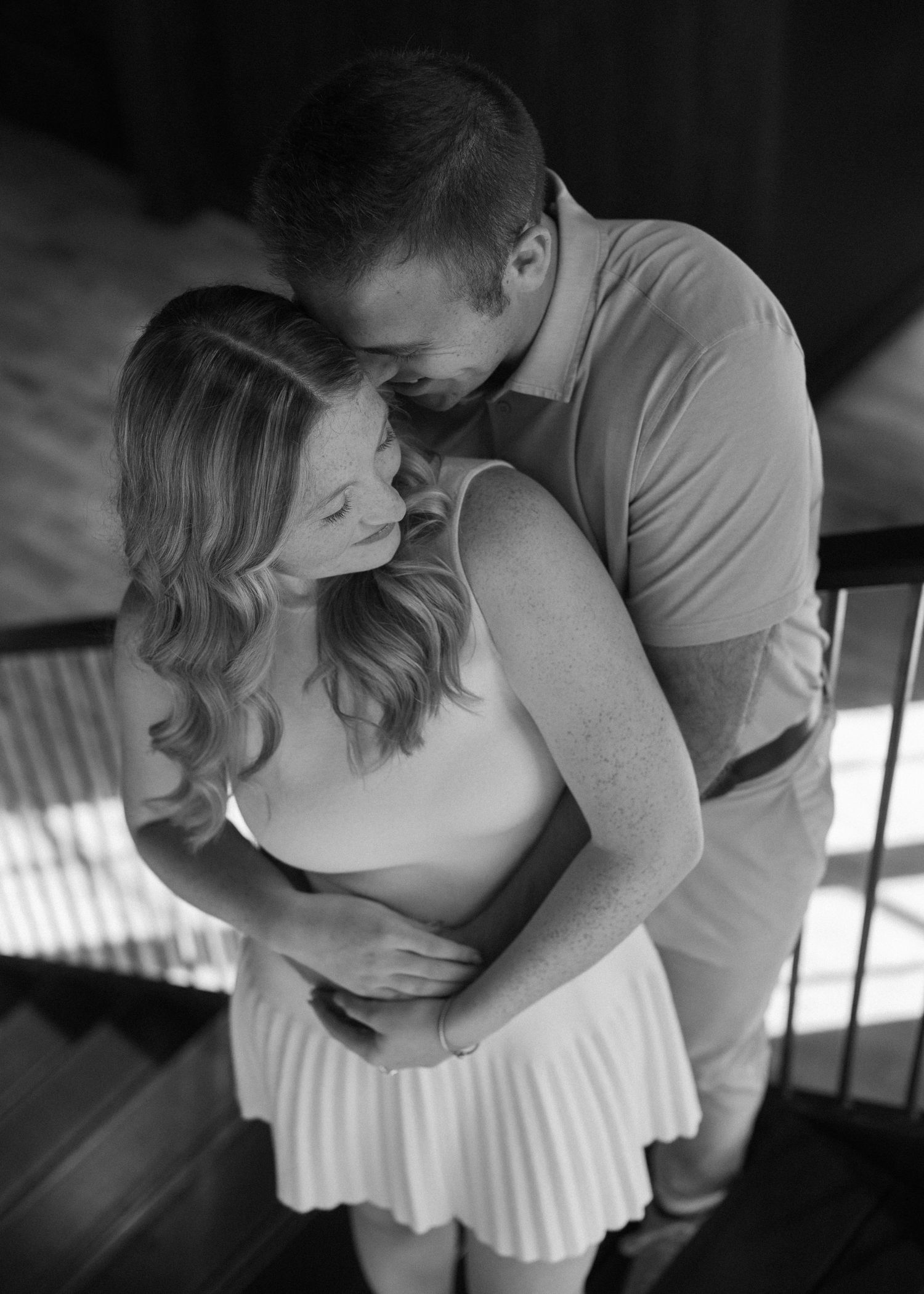 Romantic black and white photo sequence of a couple embracing in soft lighting.
