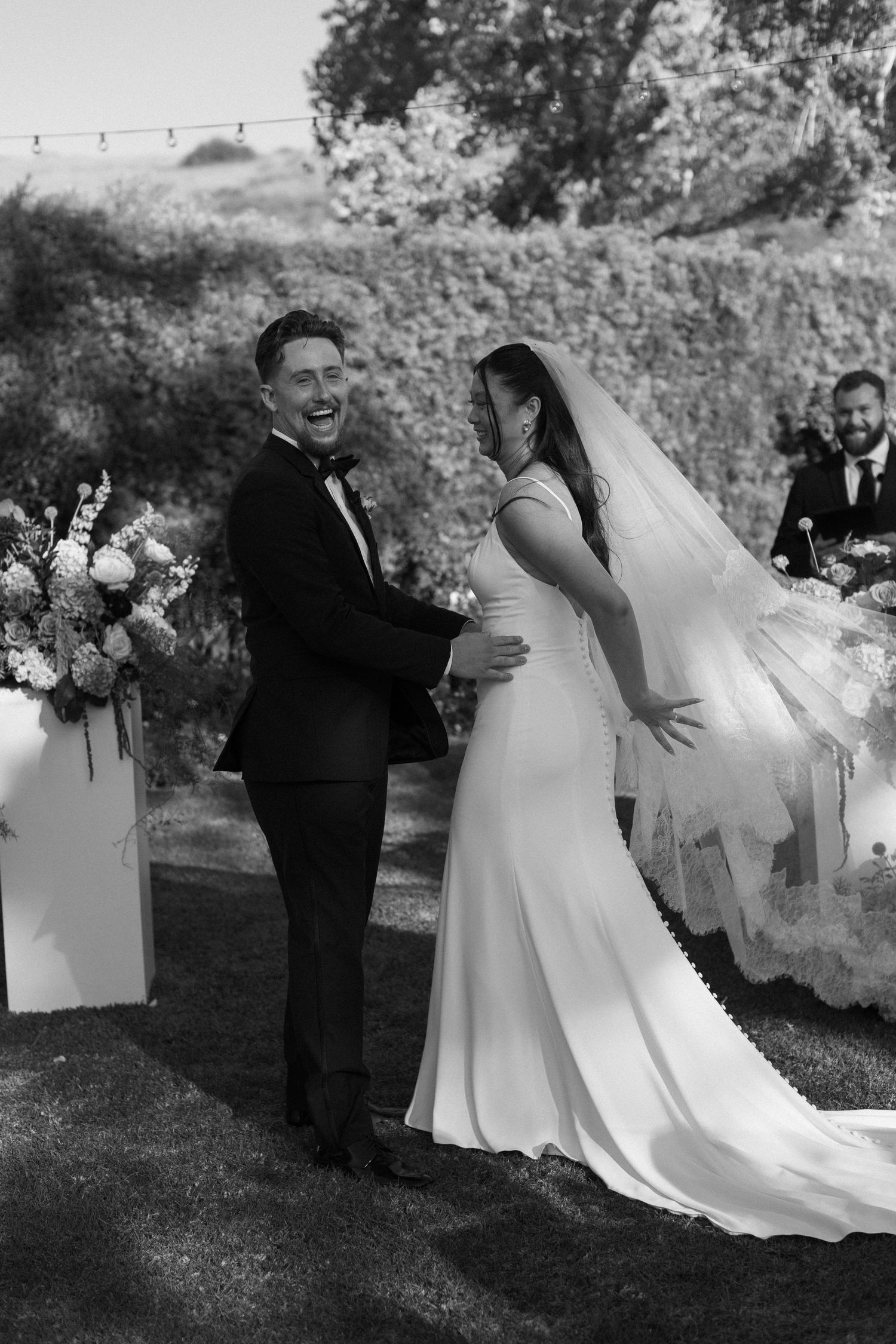 Black and white sequence of newlyweds walking together during outdoor ceremony.
