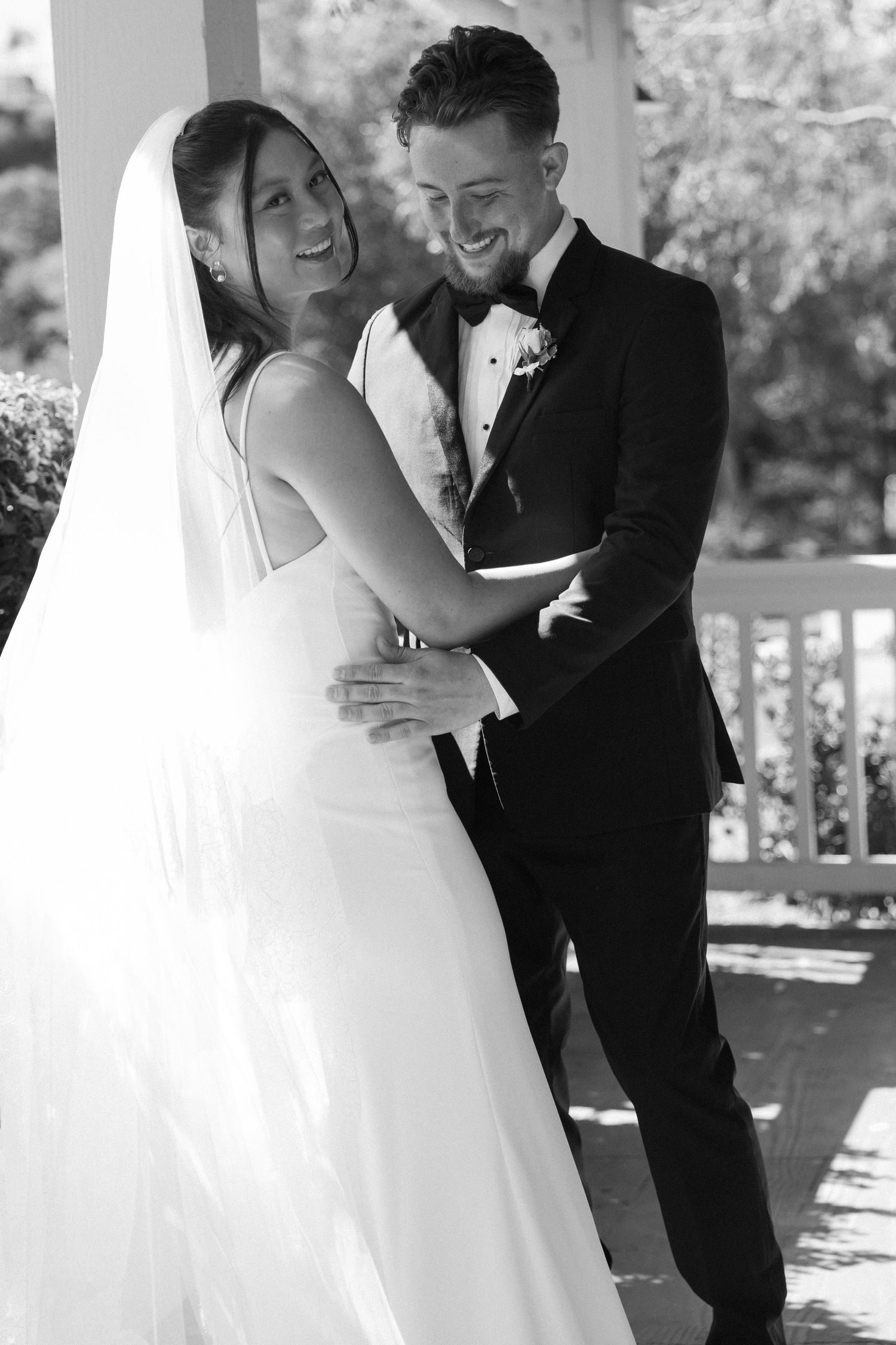 Romantic wedding couple embracing outdoors in black and white sequence.
