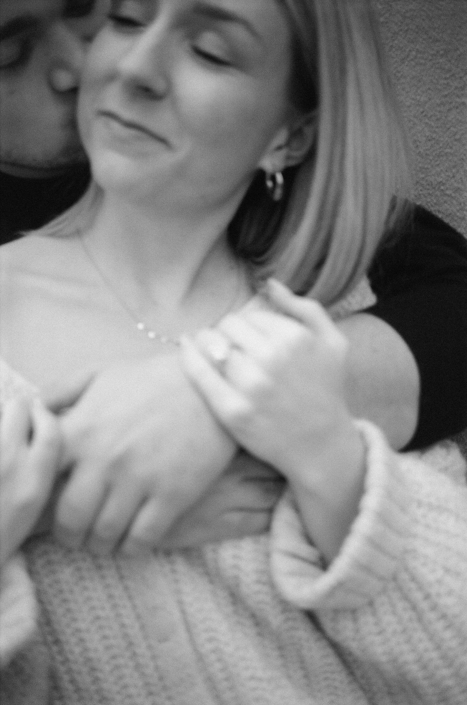 A person in a white sweater showing expressions in black and white photos.