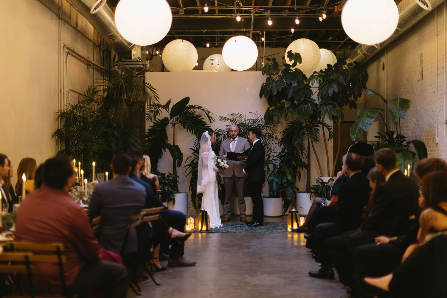 Wedding reception venue decorated with paper lanterns and ambient lighting.