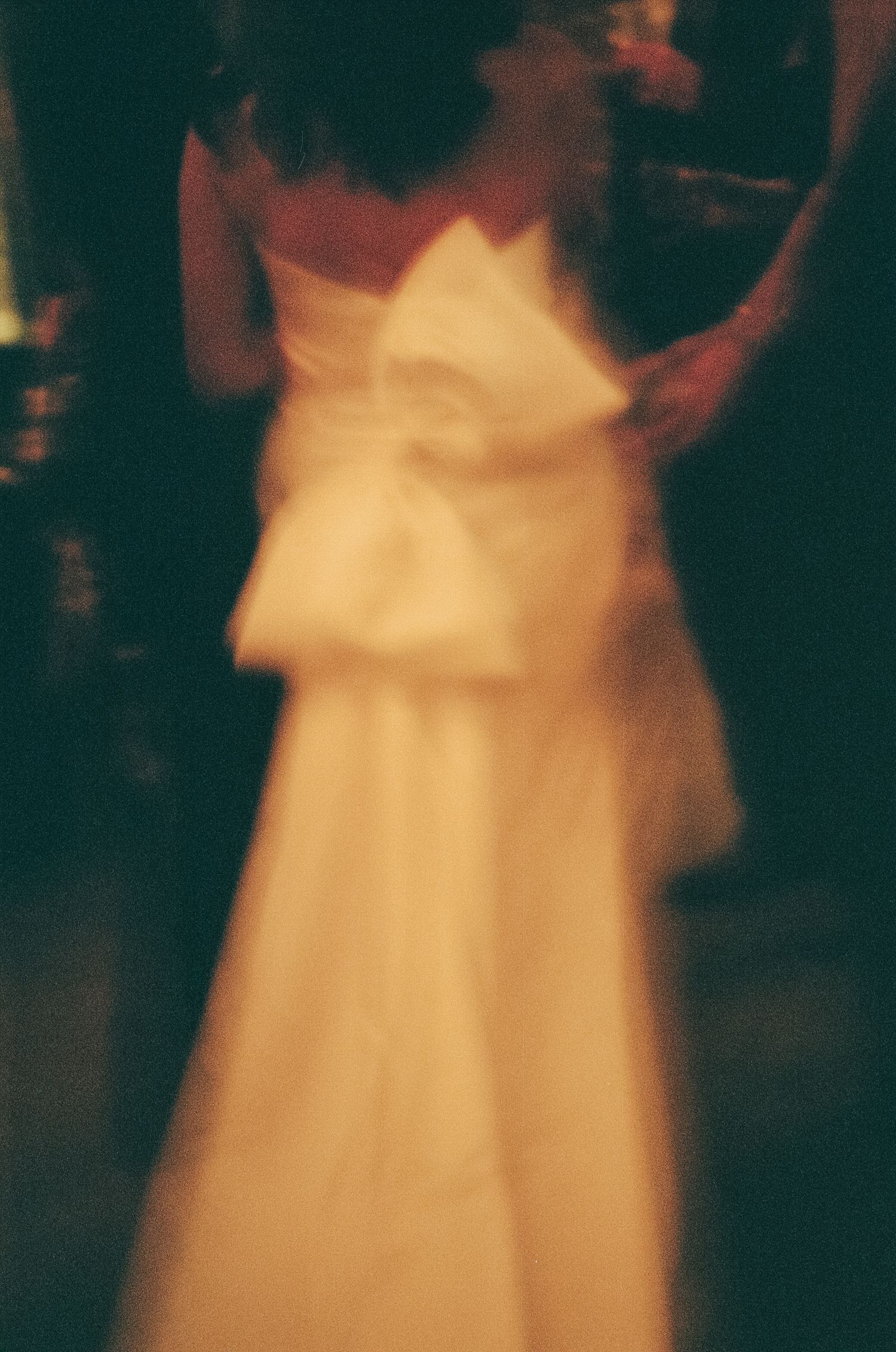 Soft focus images showing the flowing movement of a white wedding dress in dim lighting.
