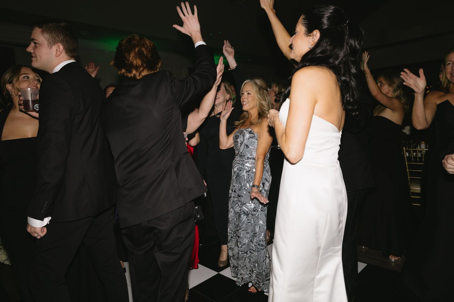 Wedding reception dance floor with guests dancing and celebrating in formal attire.