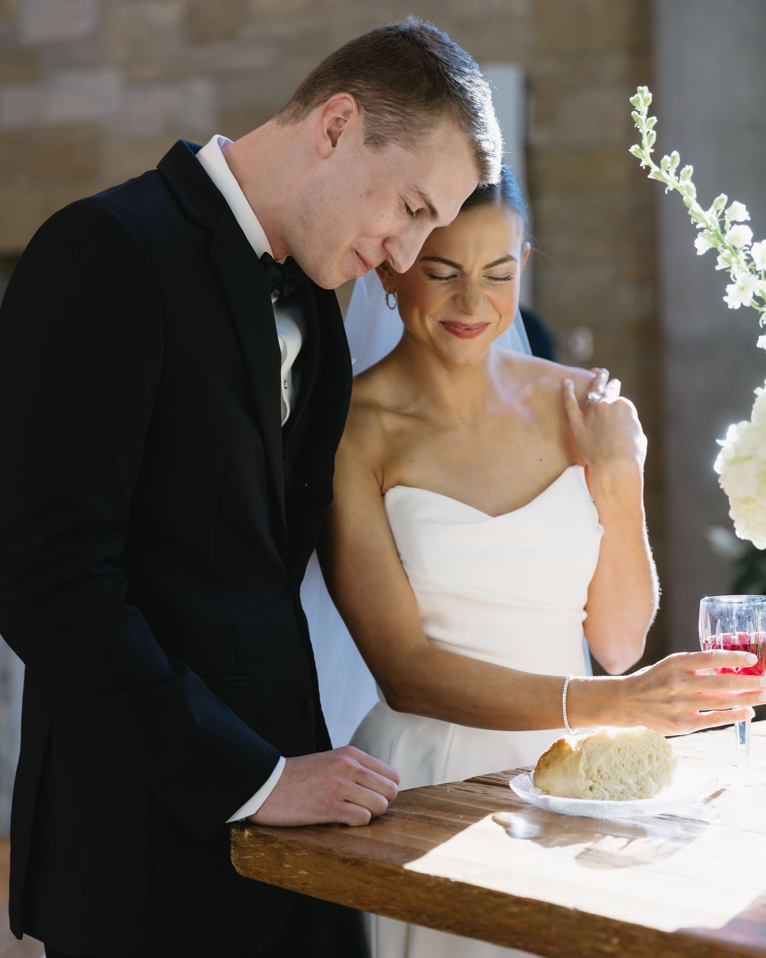 Elegant couple in formal attire sharing an intimate moment at their wedding reception.