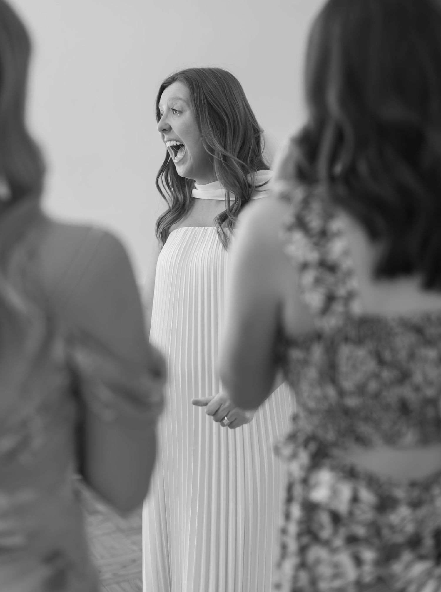 Black and white series of a woman in a flowing white dress posing elegantly outdoors against foliage.