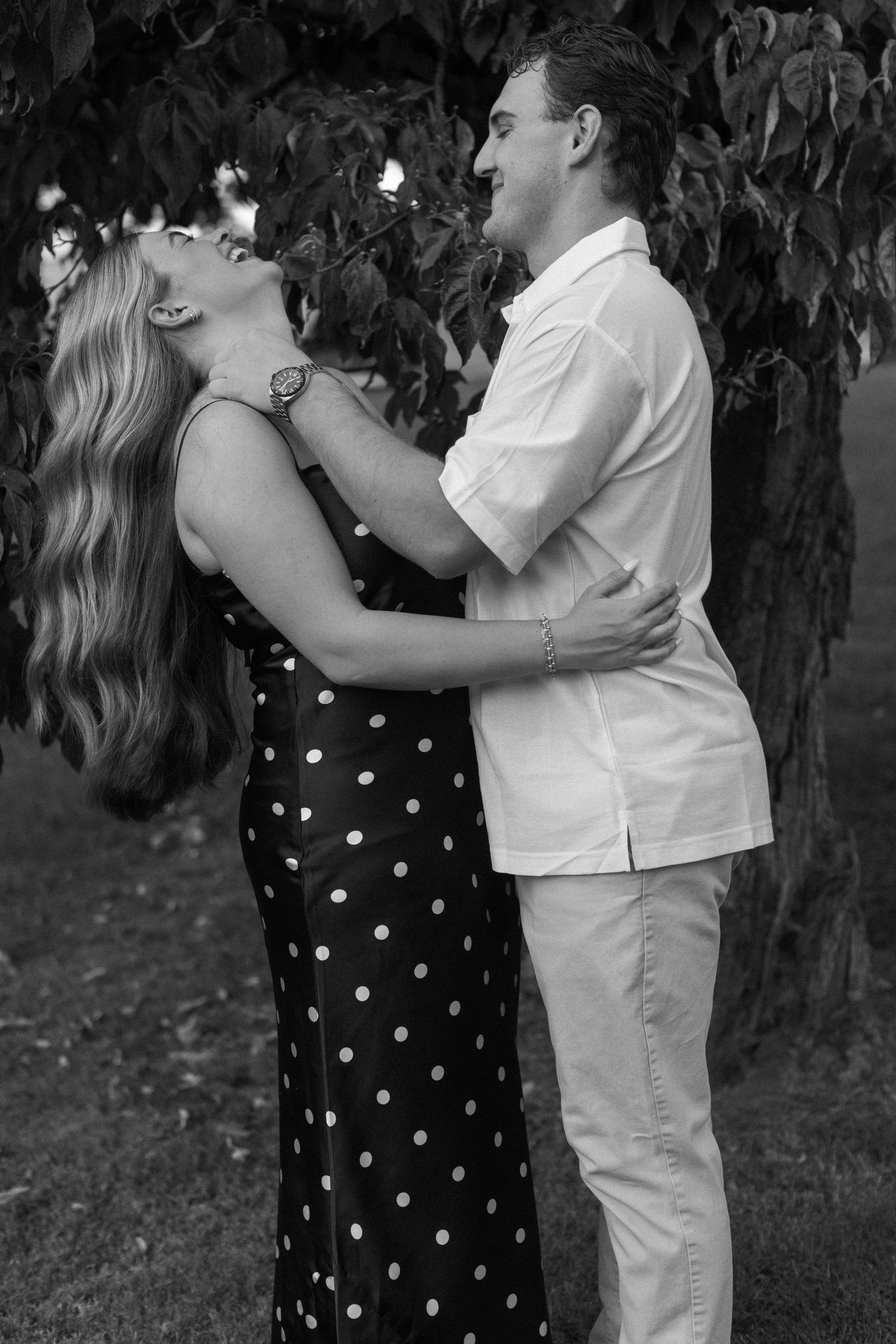 Black and white photo sequence of a couple embracing outdoors in coordinated white and polka dot outfits.