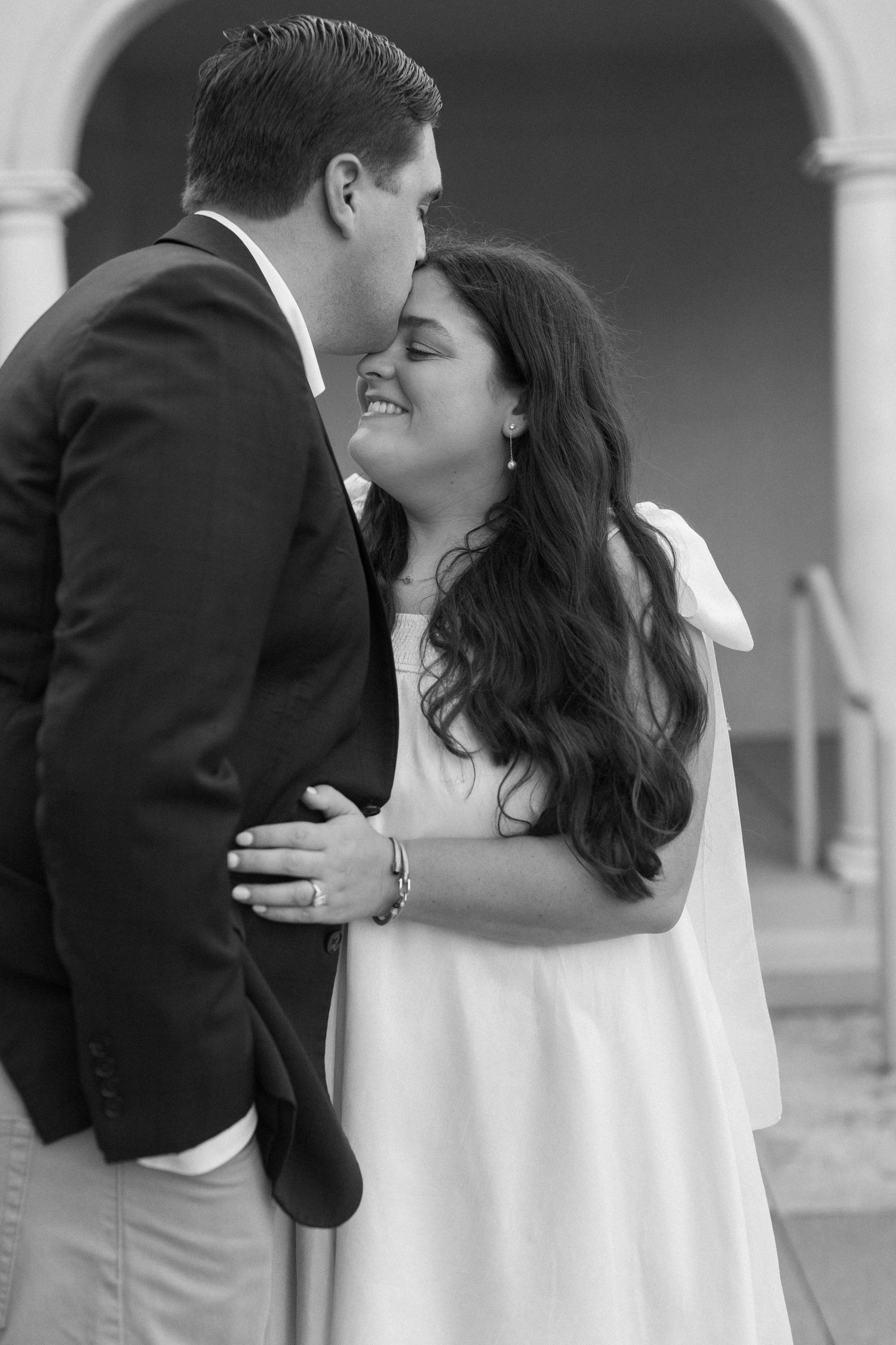 Black and white intimate portrait of a couple sharing a tender moment.