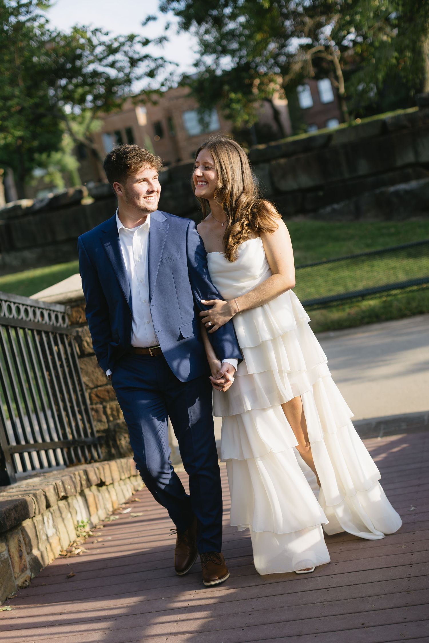 A romantic stroll along a wooden deck with stone walls and greenery in the background.