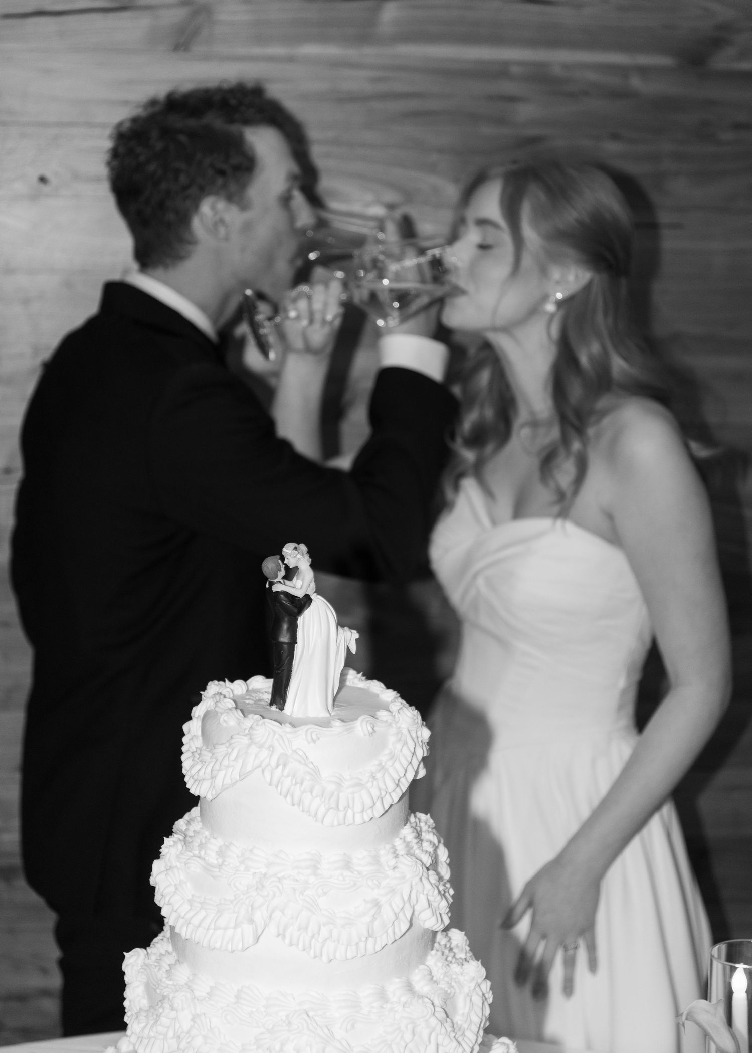 Black and white reception photos featuring elegant white wedding cake and dancing guests.