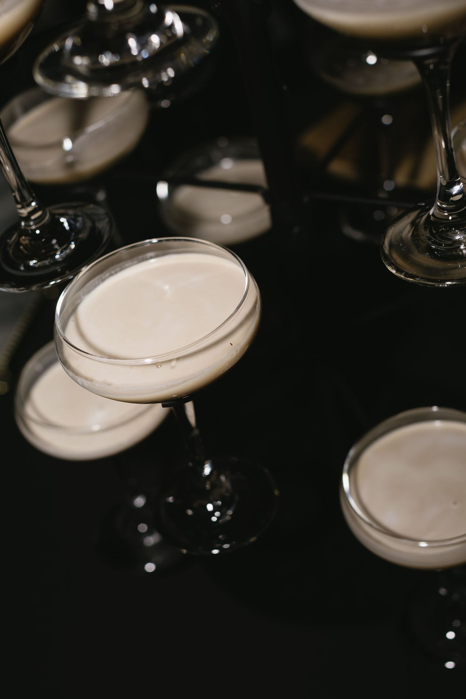 Artistic close-up of champagne glasses in dark lighting at an event.