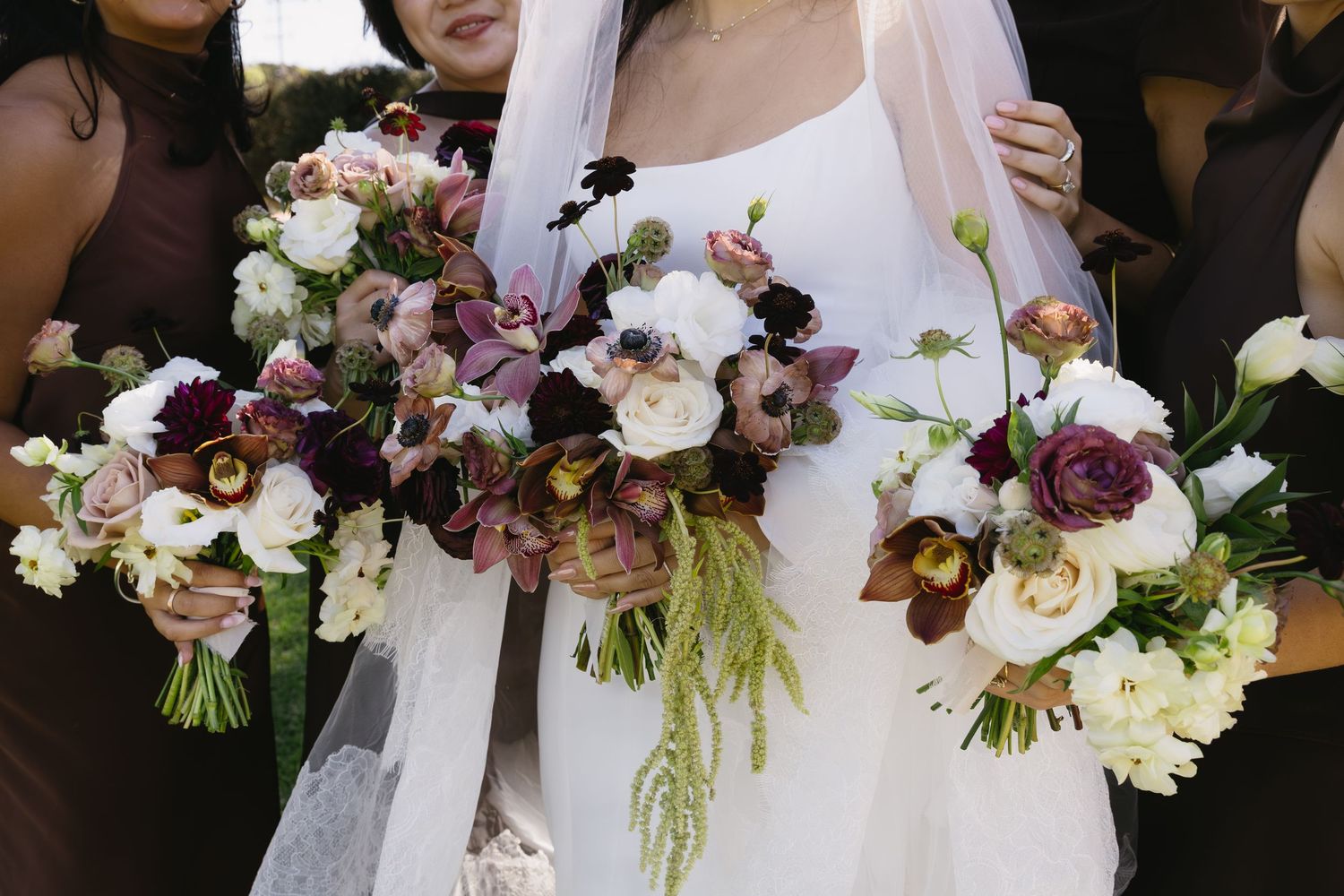 Beautiful wedding bouquets with burgundy and white flowers arranged in a row.