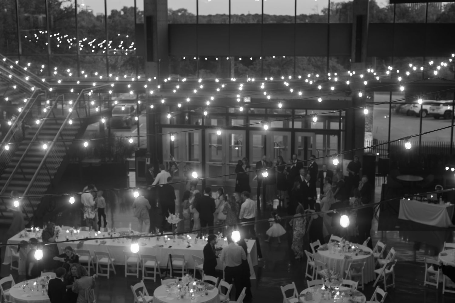 A reception venue illuminated with string lights creating a romantic ambiance for wedding guests.