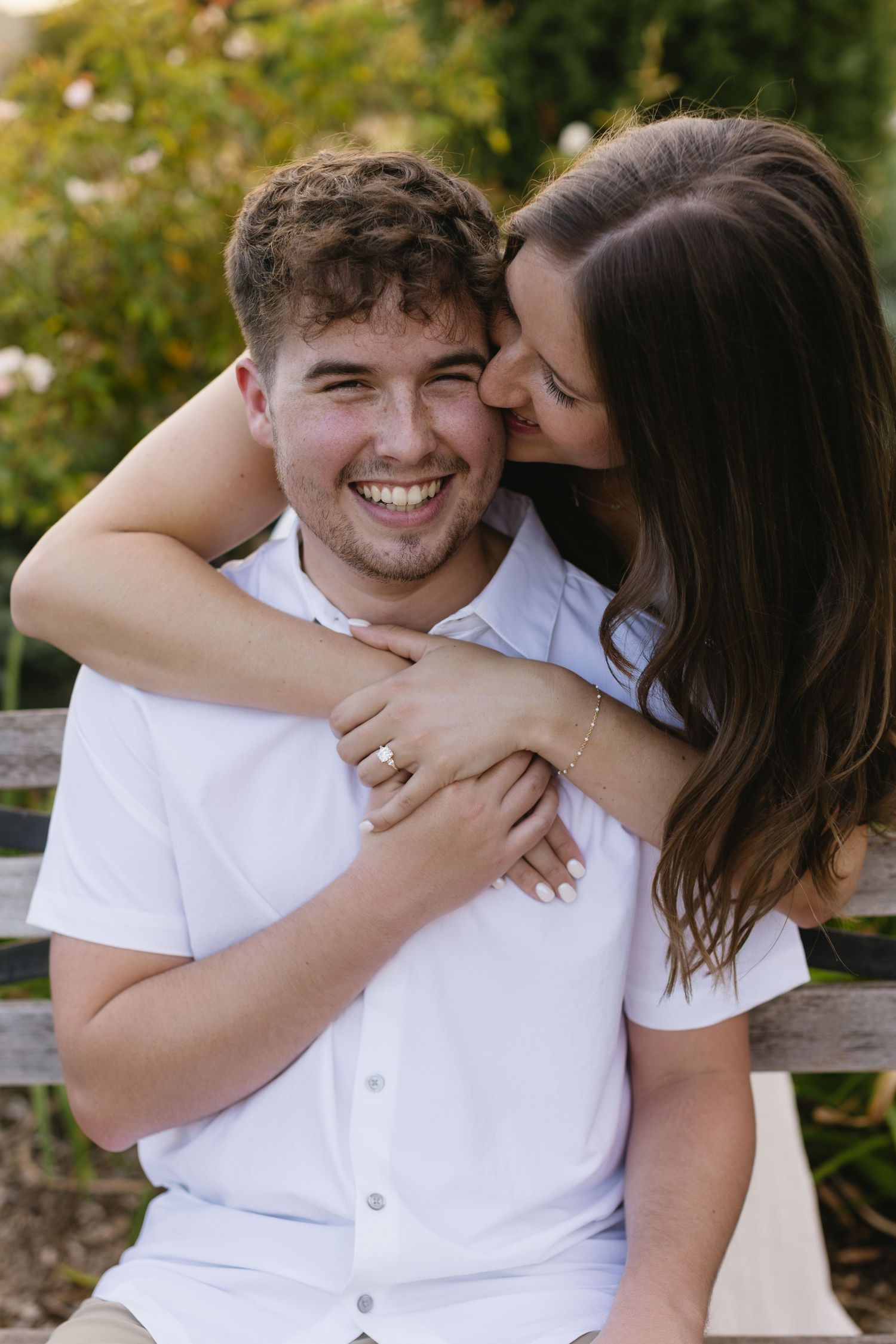 A playful moment captured on a bench showing joyful laughter and embrace.