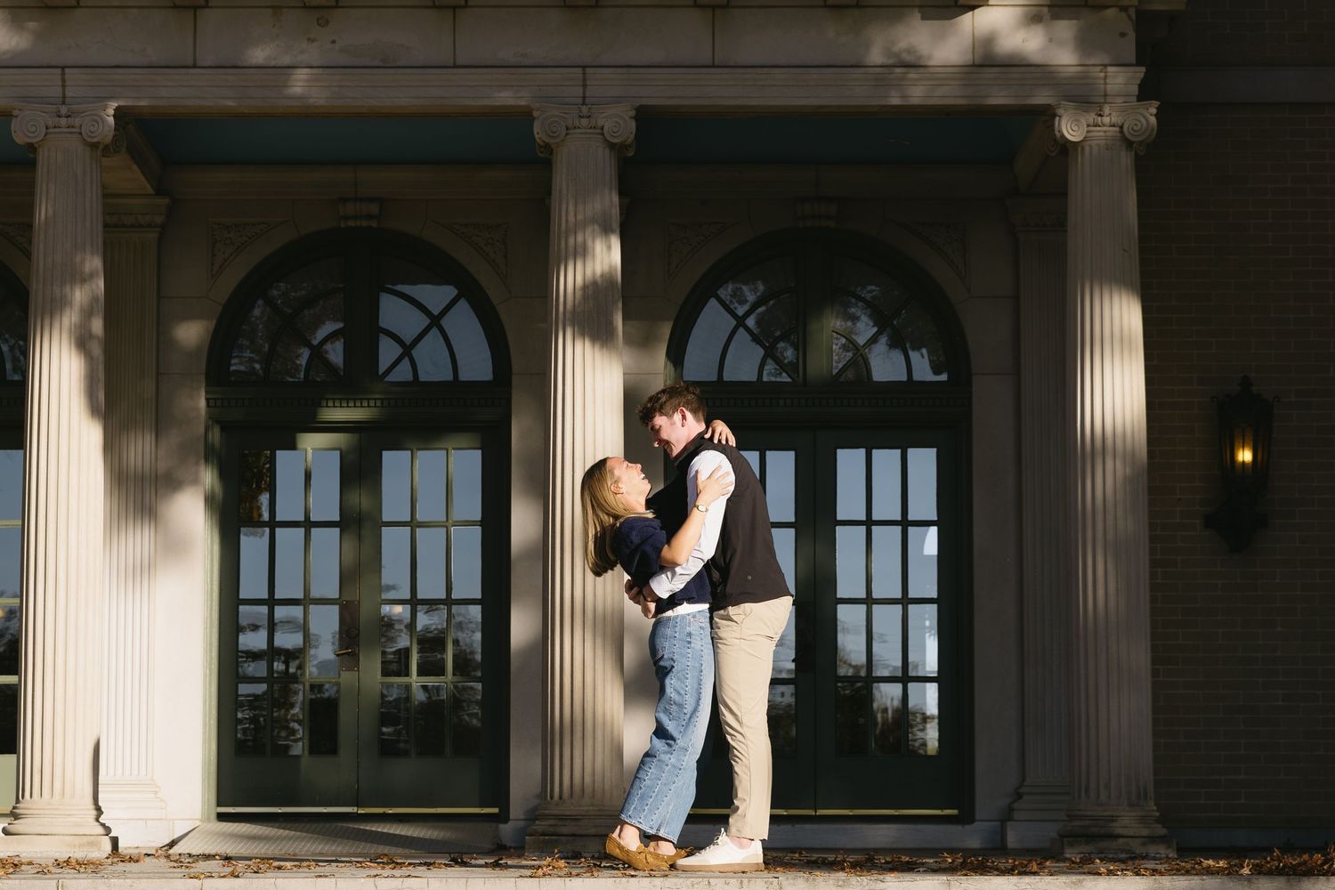 Sunlit colonnade with arched windows creating dramatic shadows.