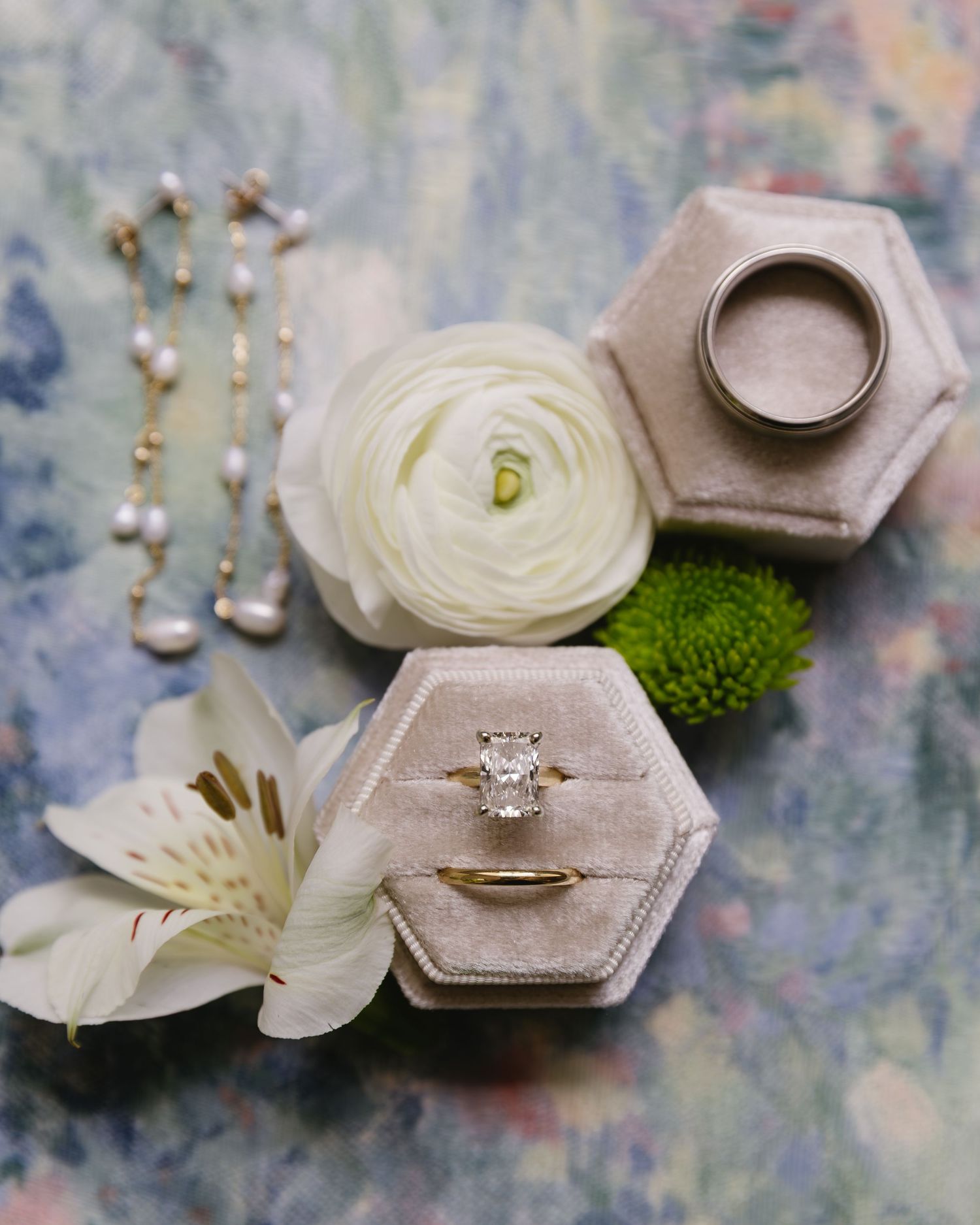 Vintage ring box with diamond engagement ring styled with white flowers and greenery in romantic photography layout.
