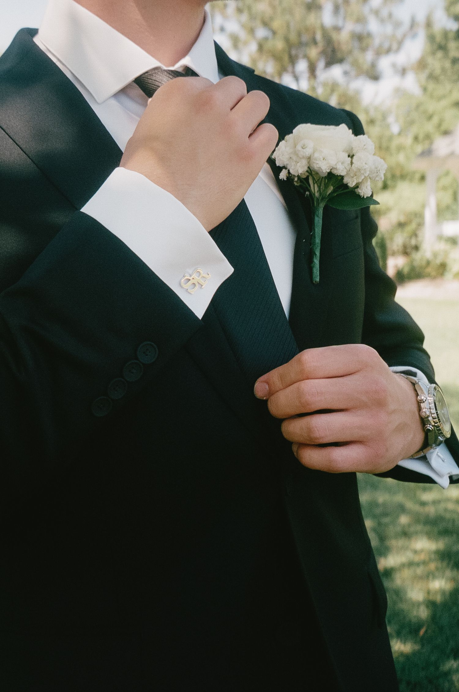 Close-up shots of formal attire showing details of black suit jackets and white dress shirts with cufflinks.