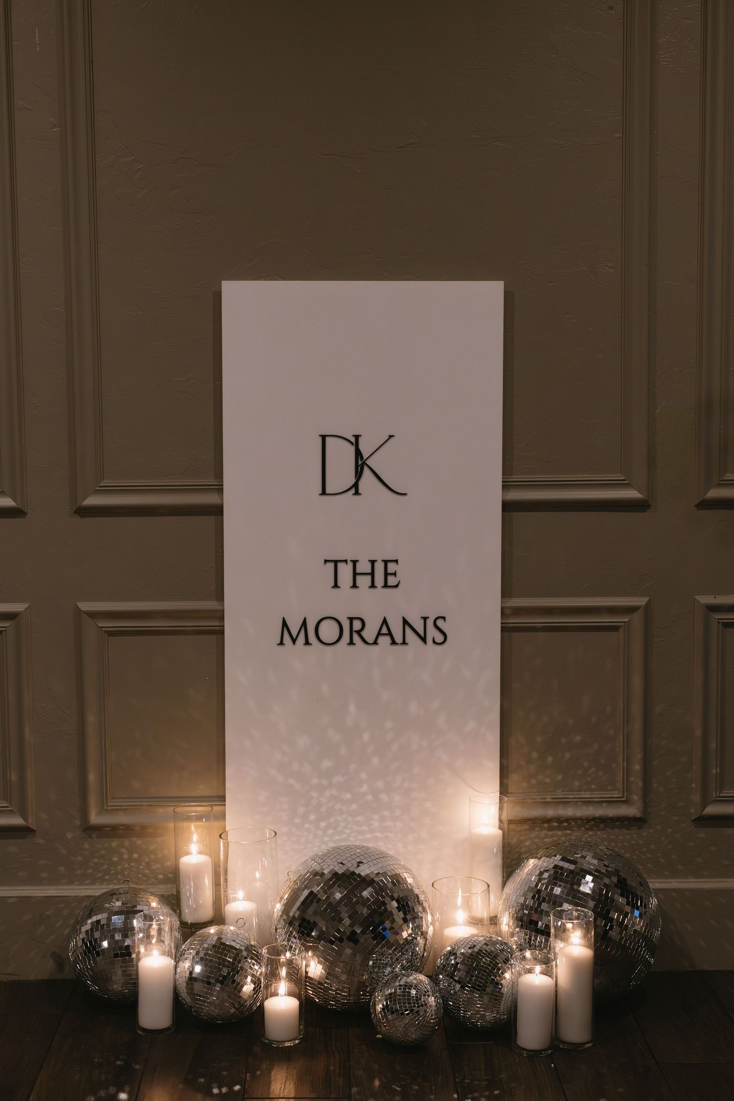 Elegant wedding reception decor with illuminated signage and candles creating a romantic atmosphere.