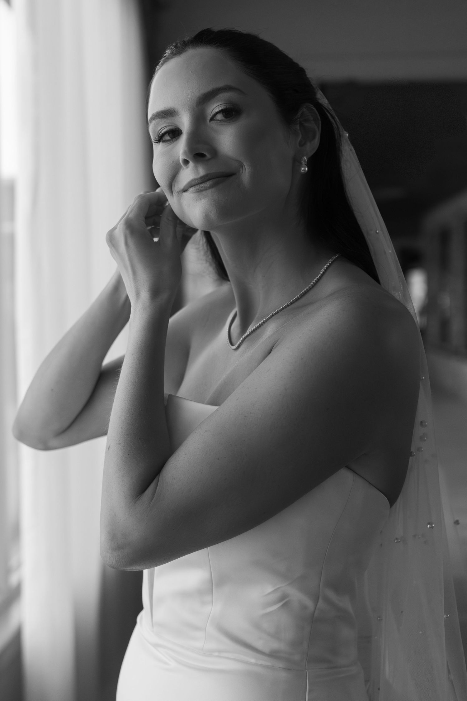 Elegant bridal portrait in black and white showing wedding day jewelry and veil.
