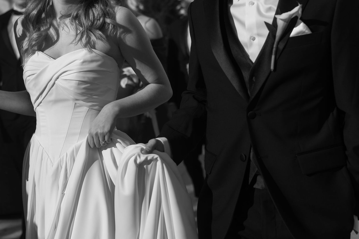 Wedding party members pose together in formal black and white attire.