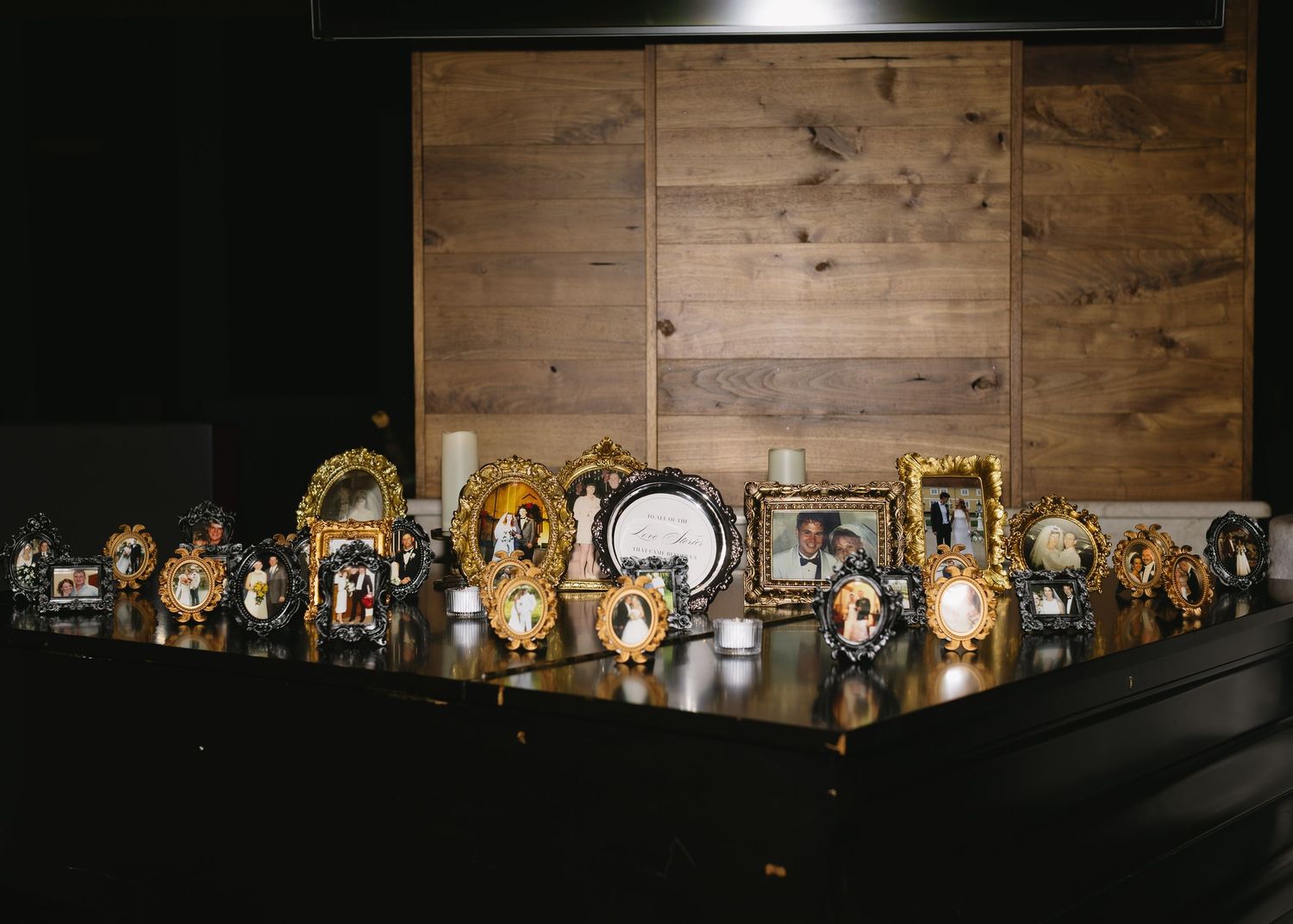 A row of illuminated vintage frames and decorative items displayed on wooden shelving.
