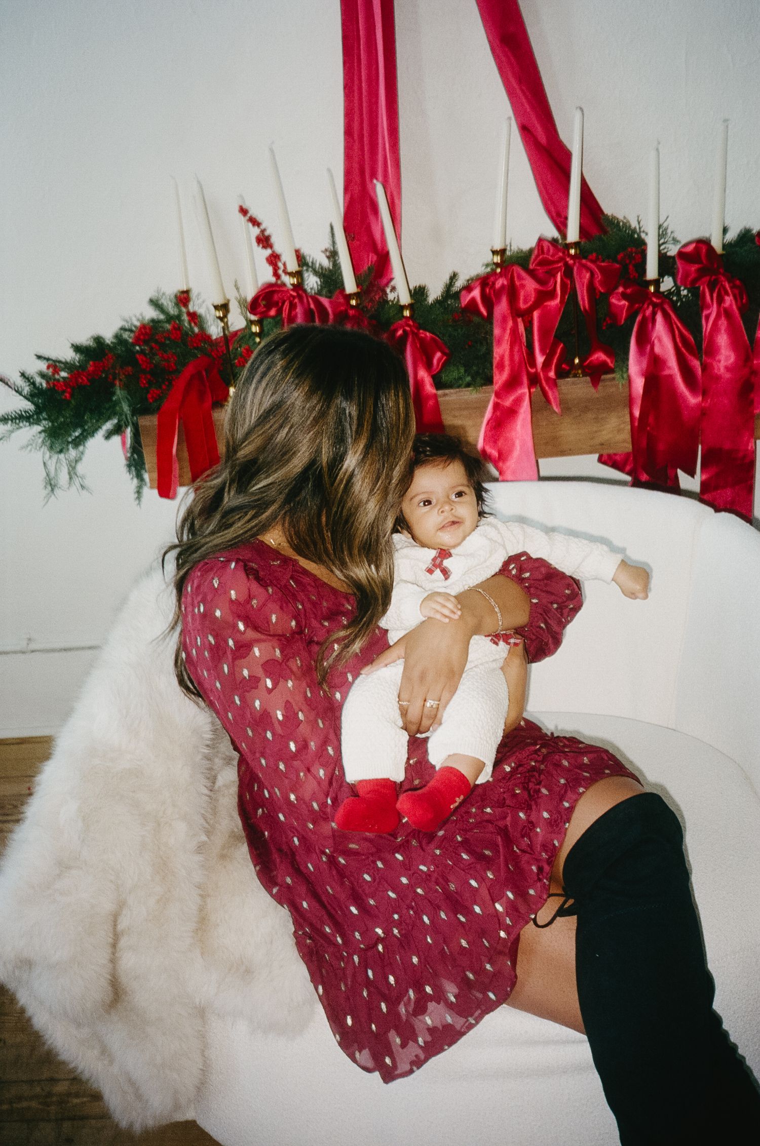A series of playful shots showing someone in a red polka dot dress swinging from red ribbons against a white backdrop.