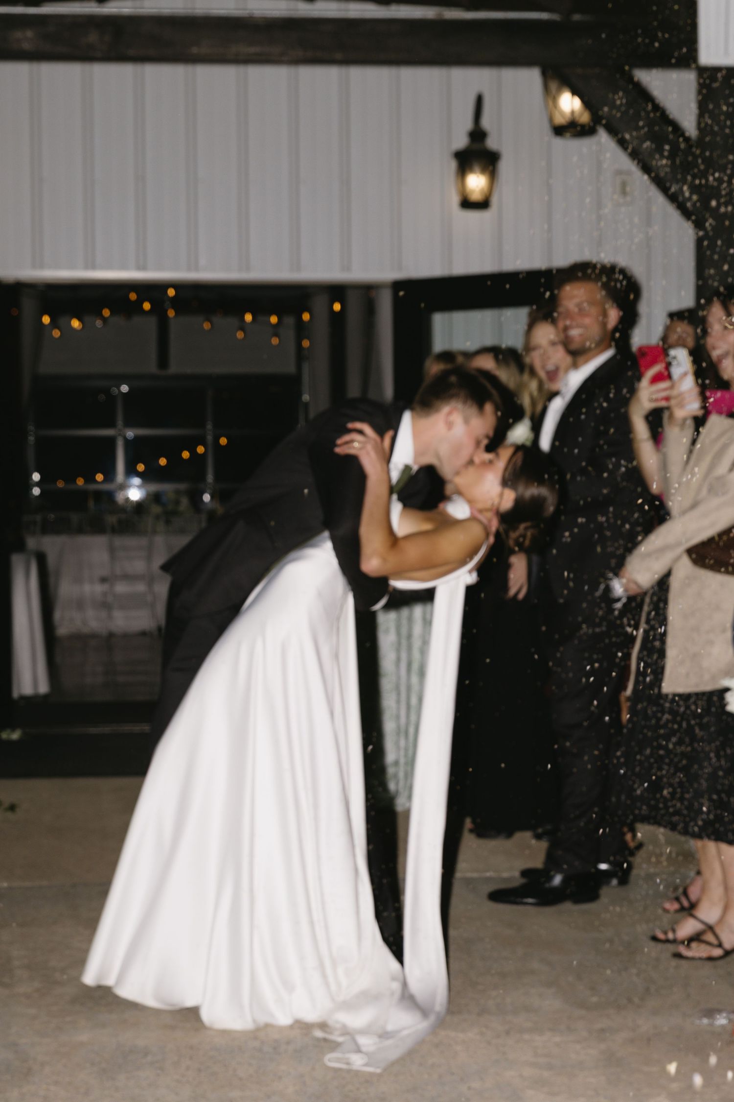 Wedding reception dance floor scene with twirling white dress under evening lights.