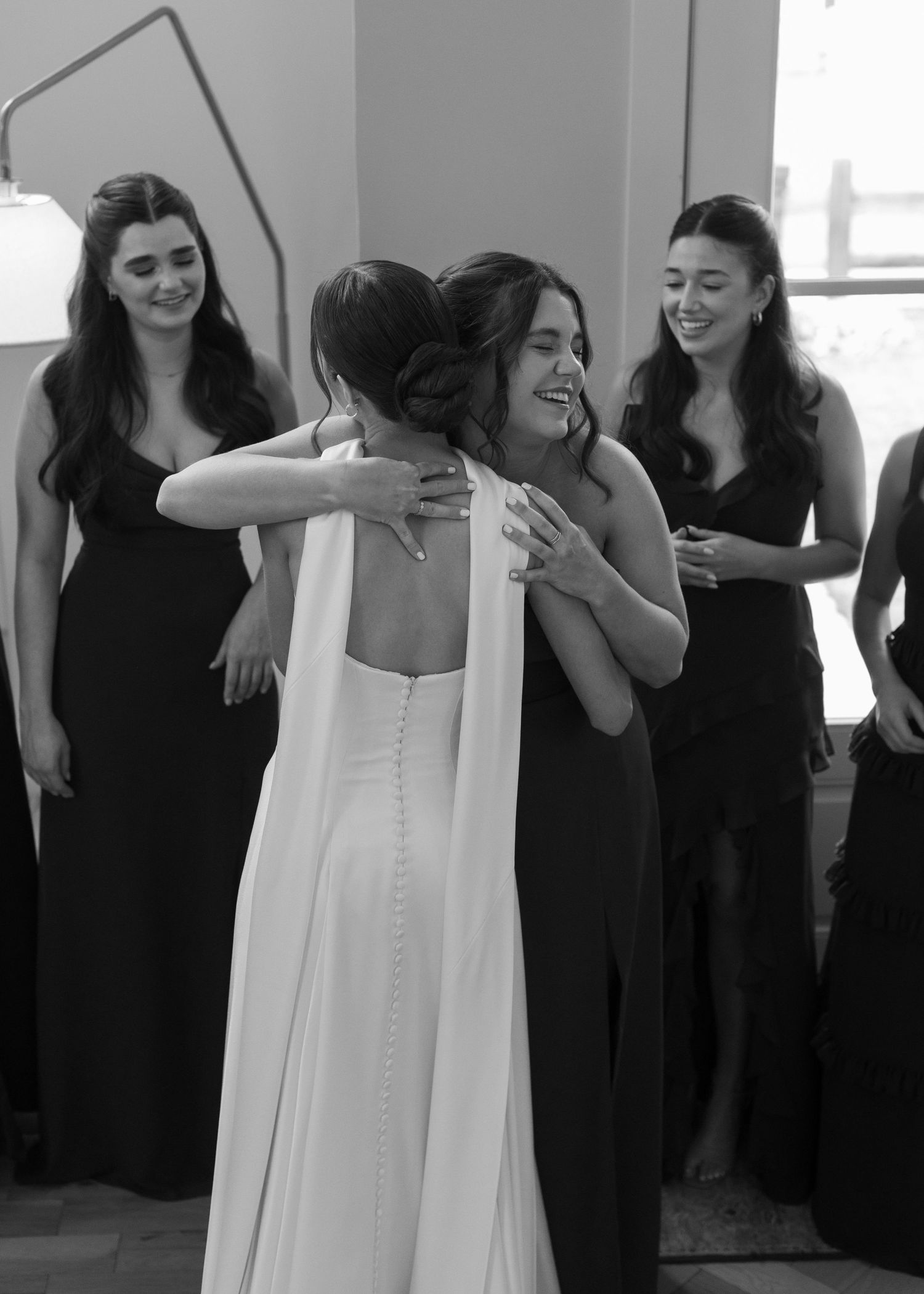 Bridesmaids in elegant black dresses gather together during a wedding celebration.