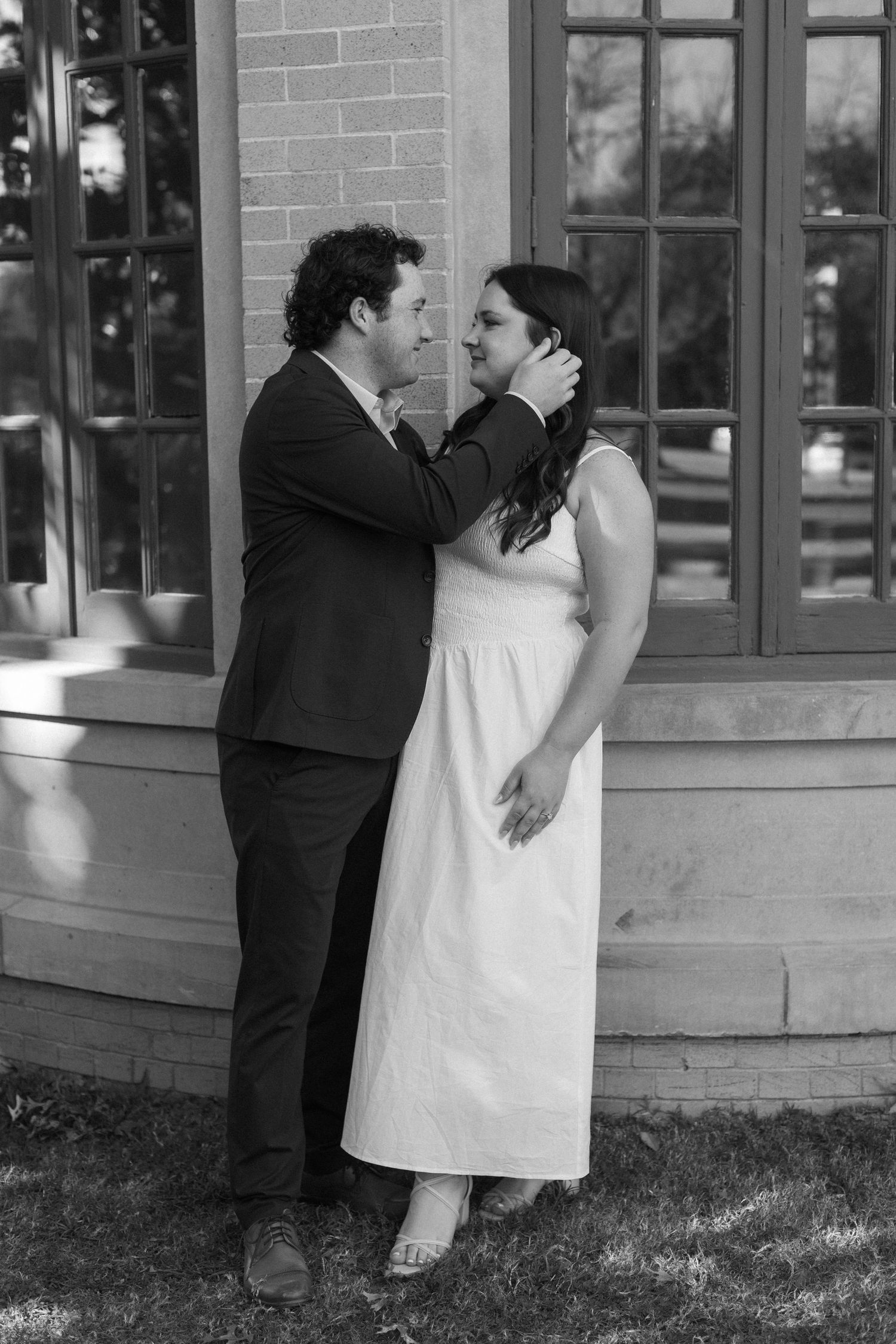 Black and white series showing romantic moments against brick building exterior.