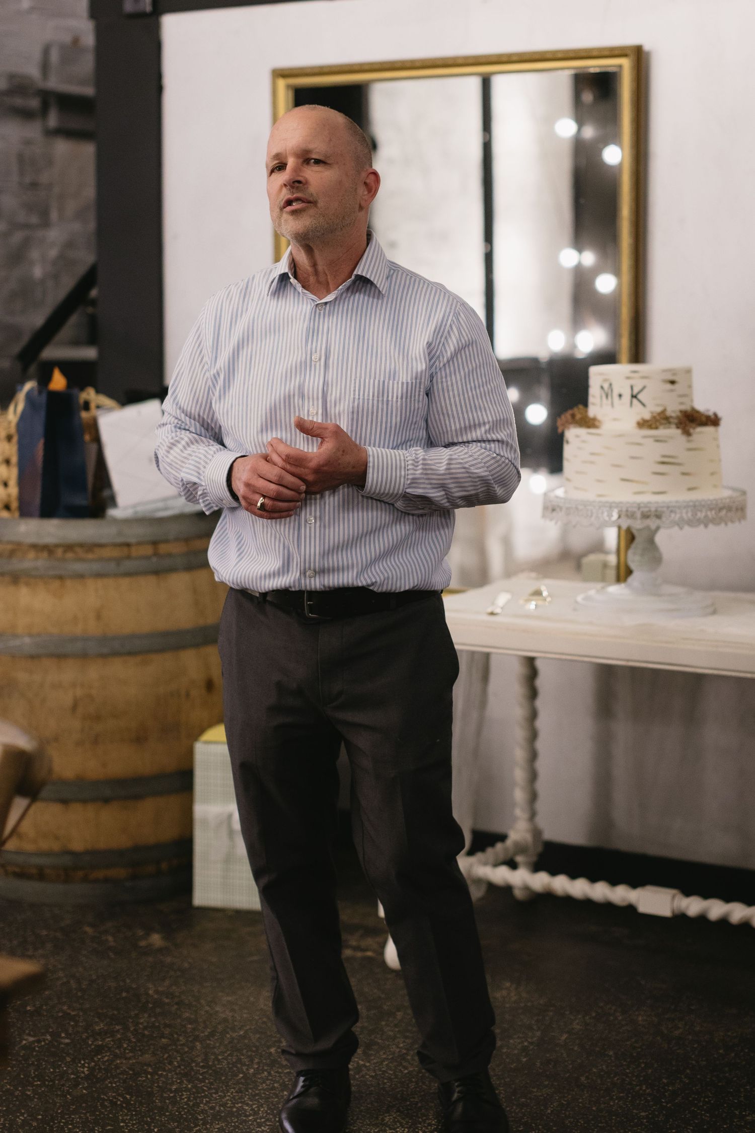 Event space decorated with rustic wine barrels and elegant white cake display.