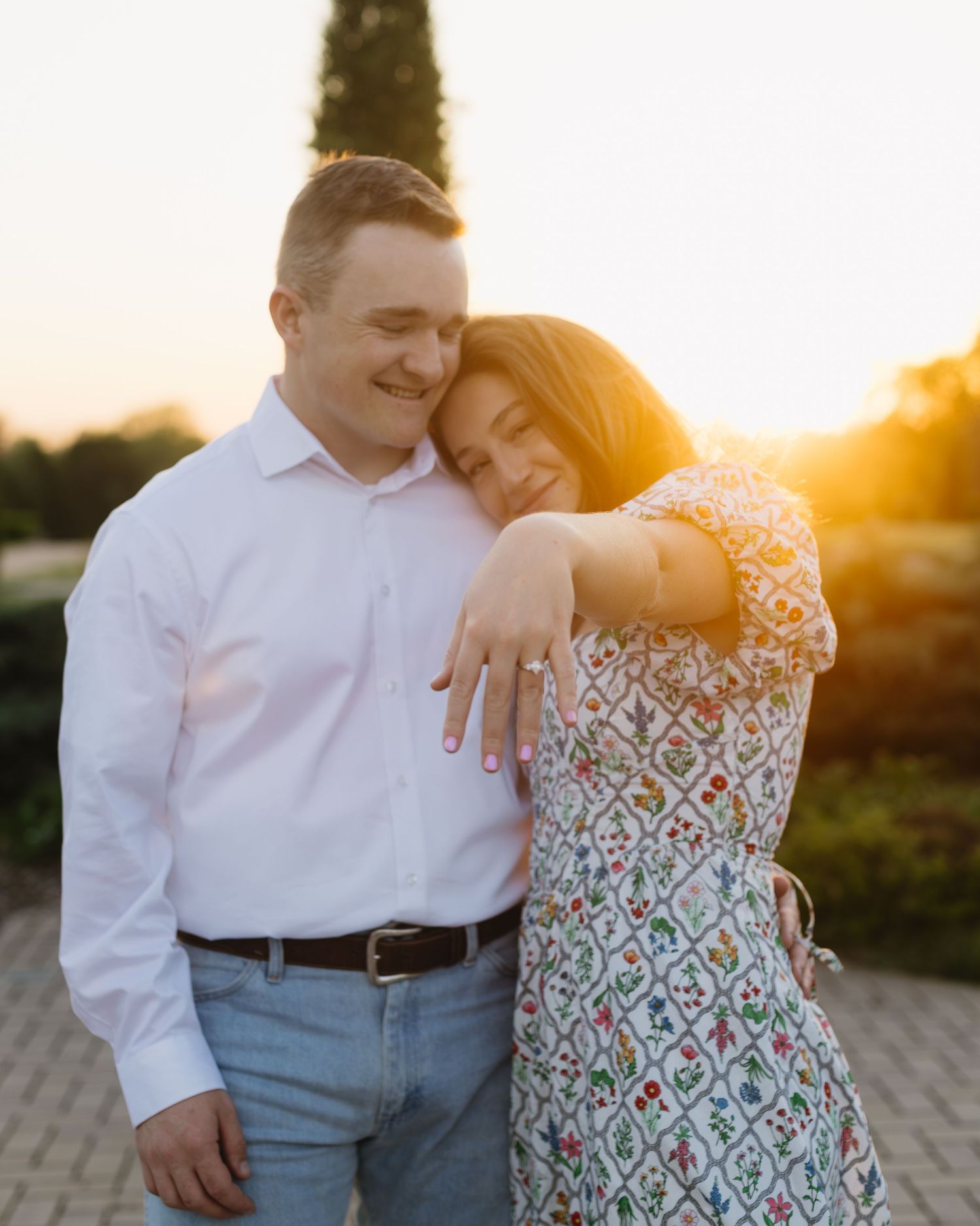A couple shares intimate moments at sunset with golden light illuminating their embrace.