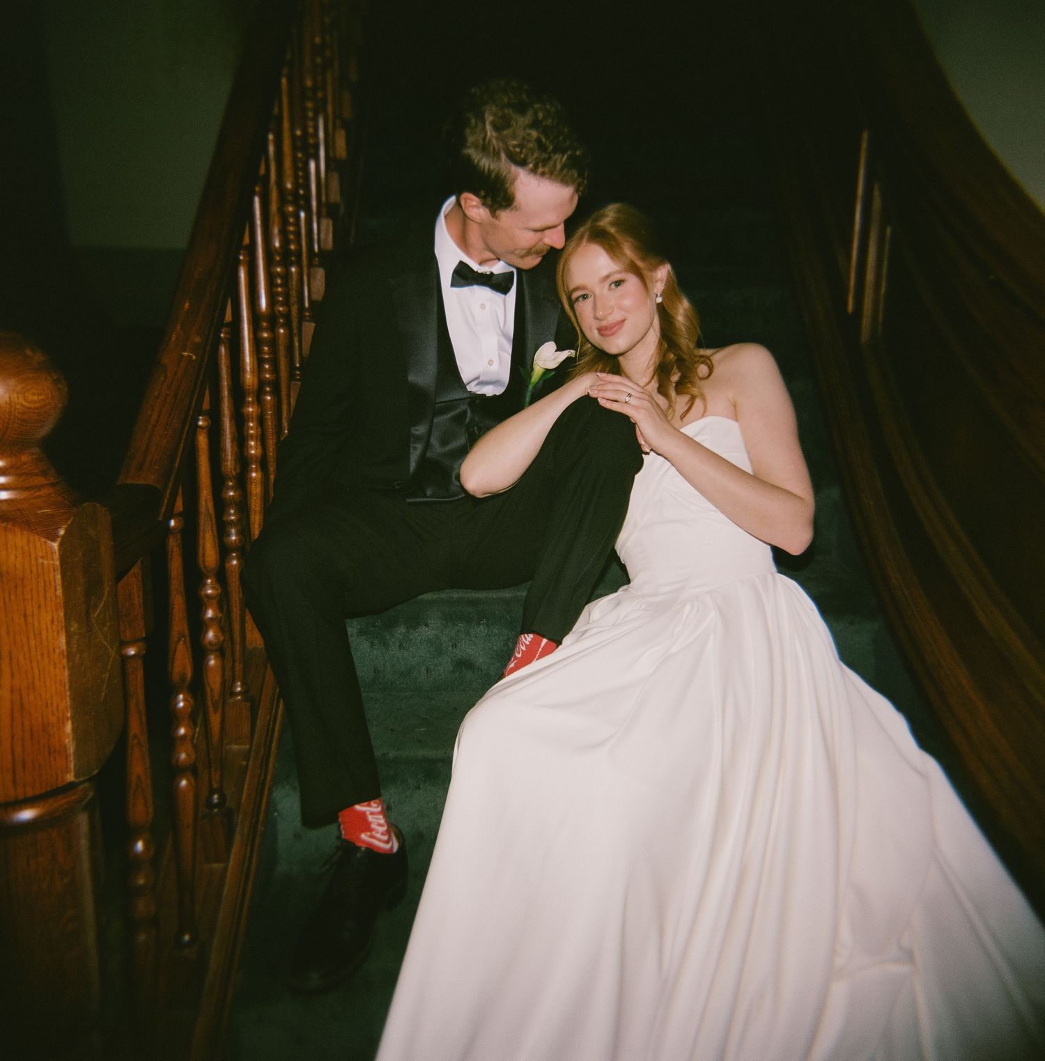 A couple shares an intimate dance moment on a wooden staircase.