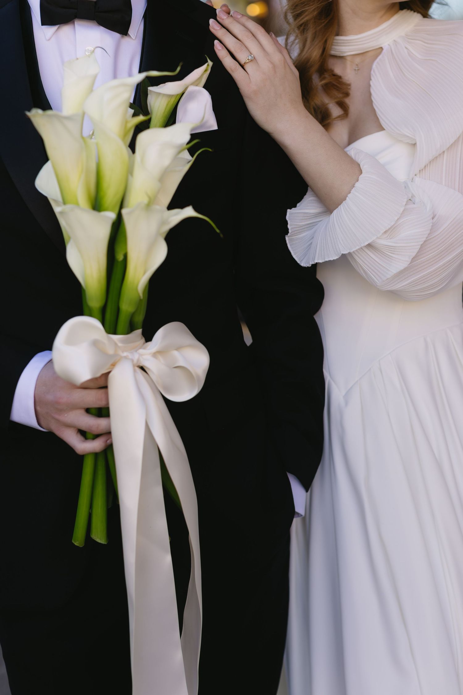Wedding detail shots featuring white calla lily bouquets with silk ribbons.