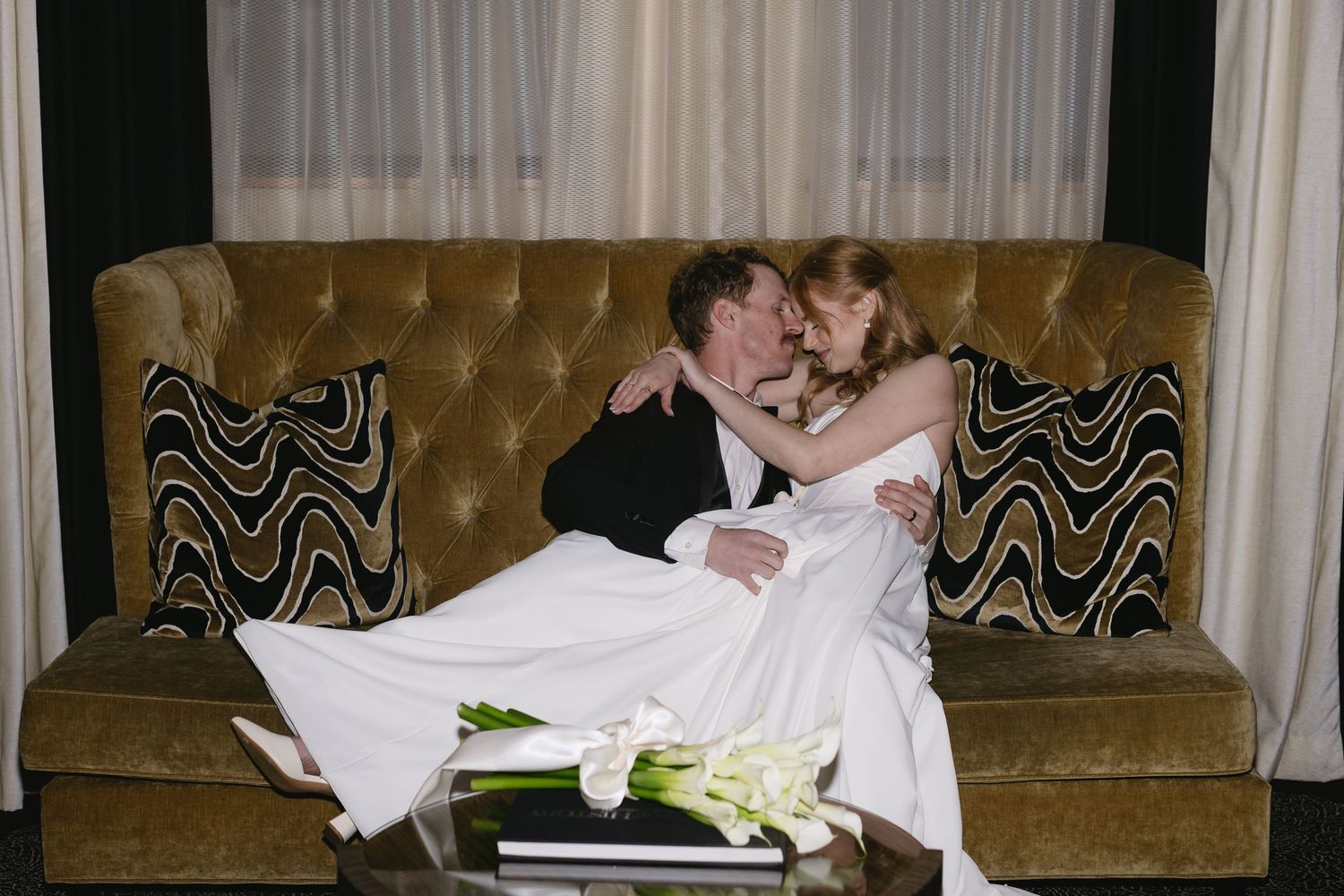 Wedding couple relaxing on vintage brown leather seating.