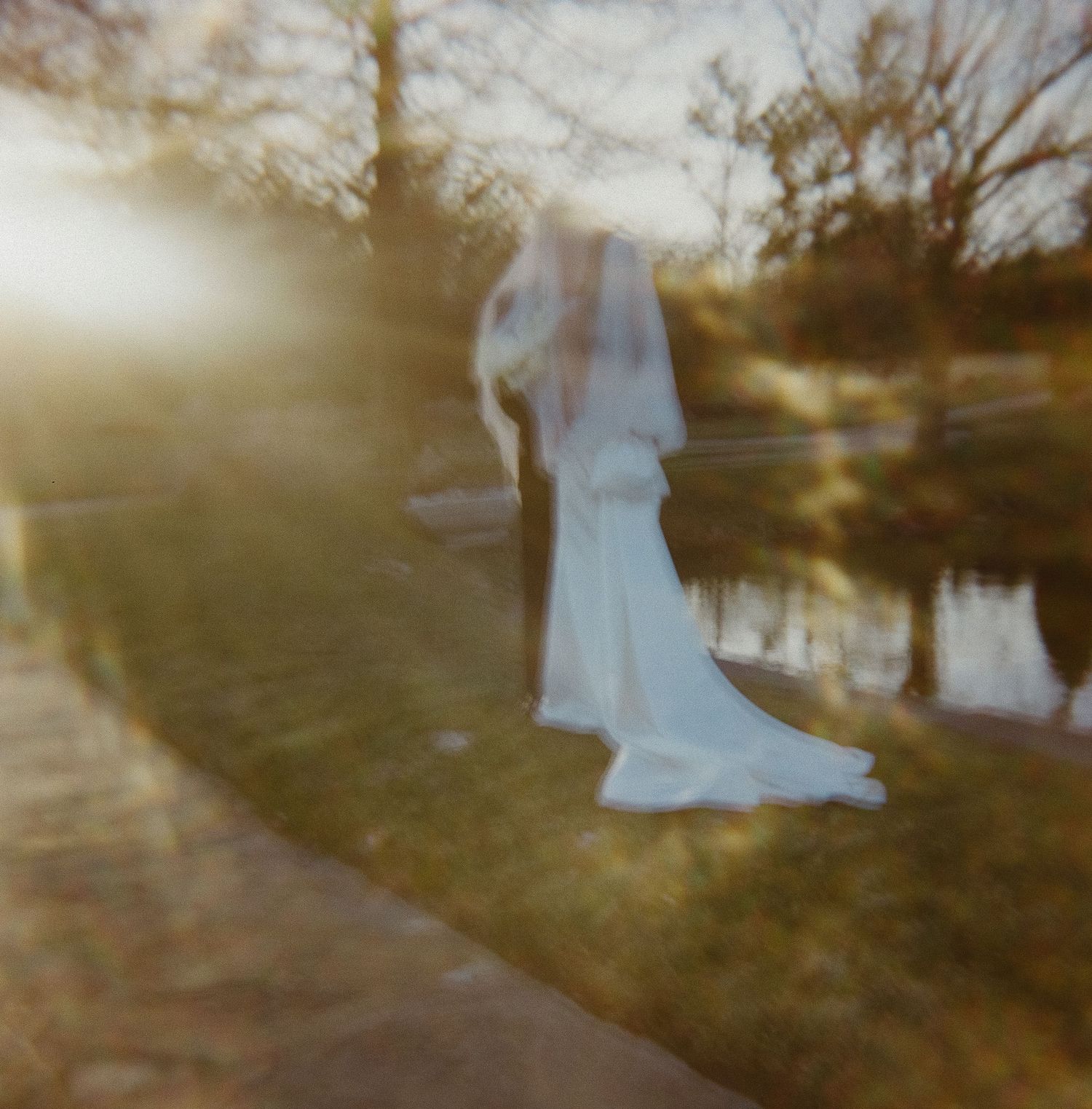 Dreamy sunset wedding photo with ethereal light and water reflection.