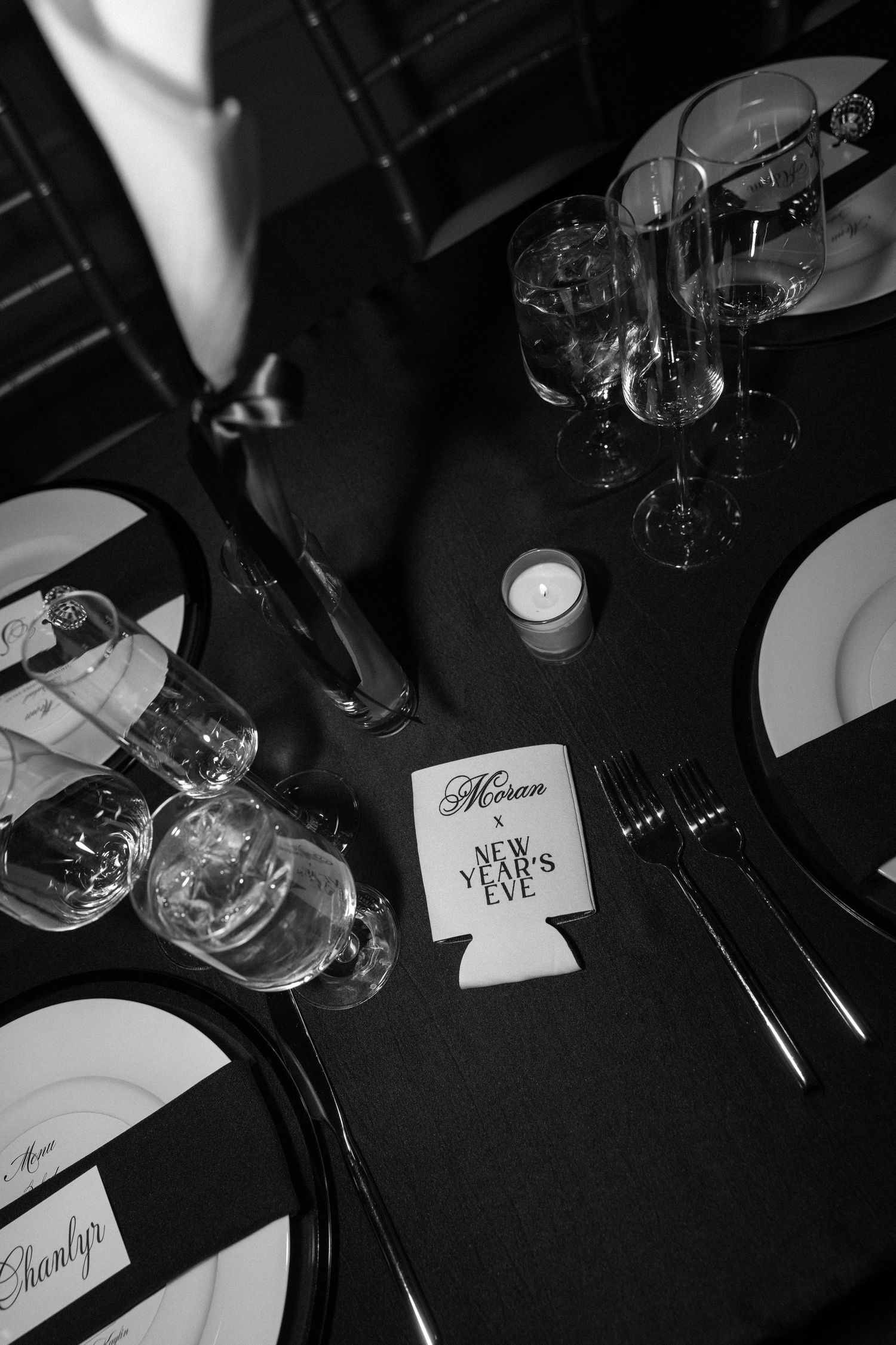 Black and white table settings with personalized name cards at formal wedding reception.