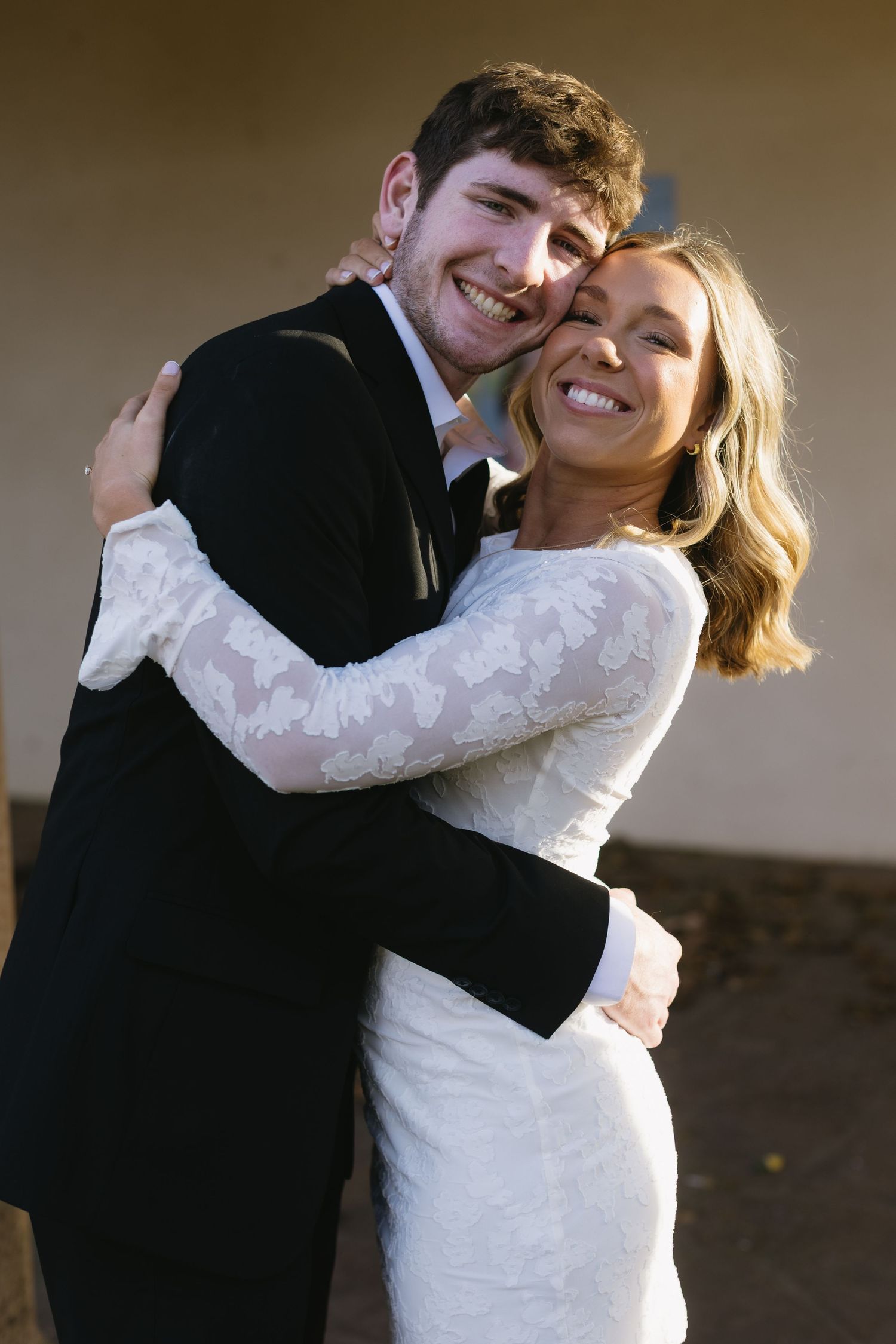 A joyful embrace captured between a couple in formal wear sharing a laugh together.