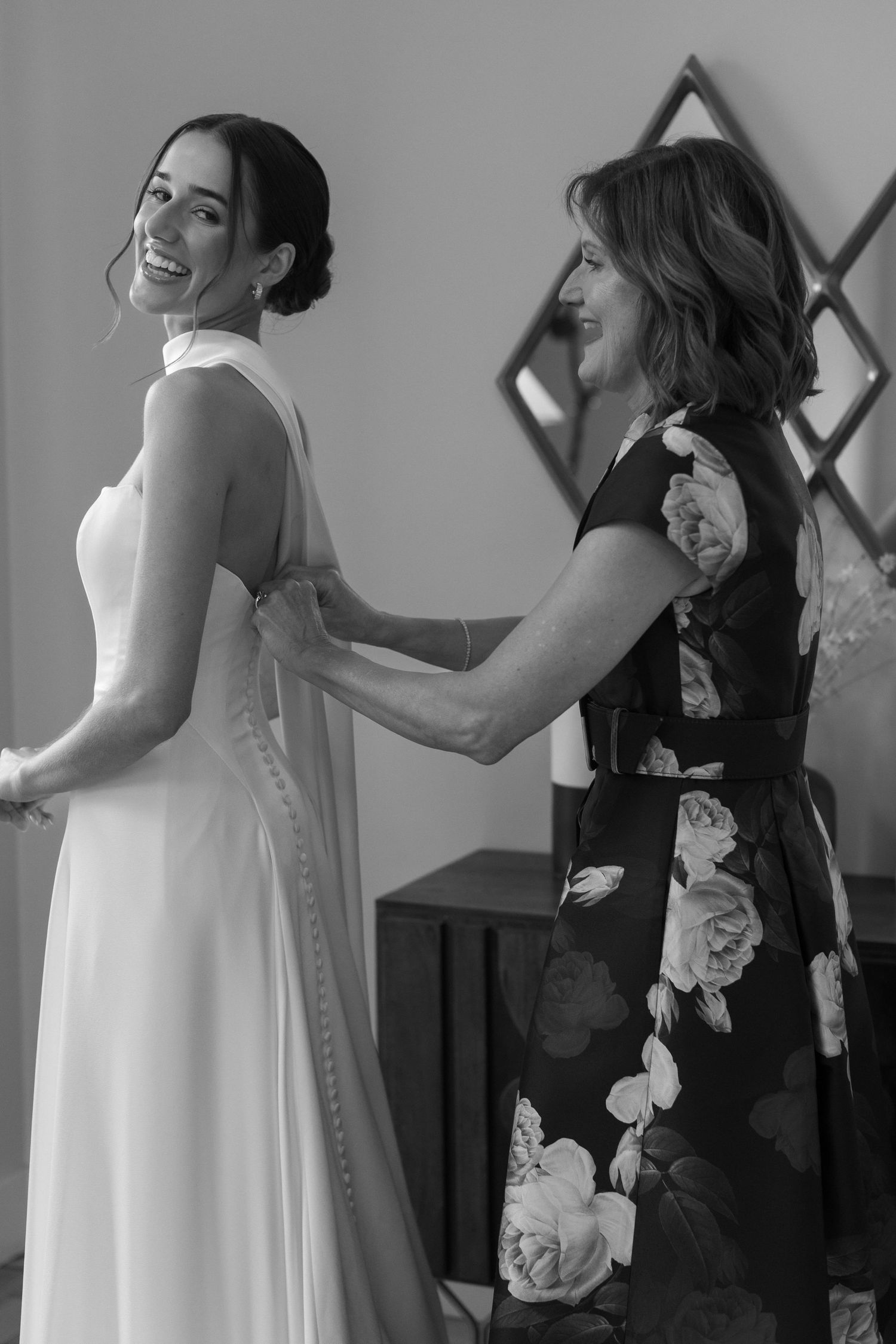 Wedding preparation scene showing flowing white gown and black bridesmaid dresses.