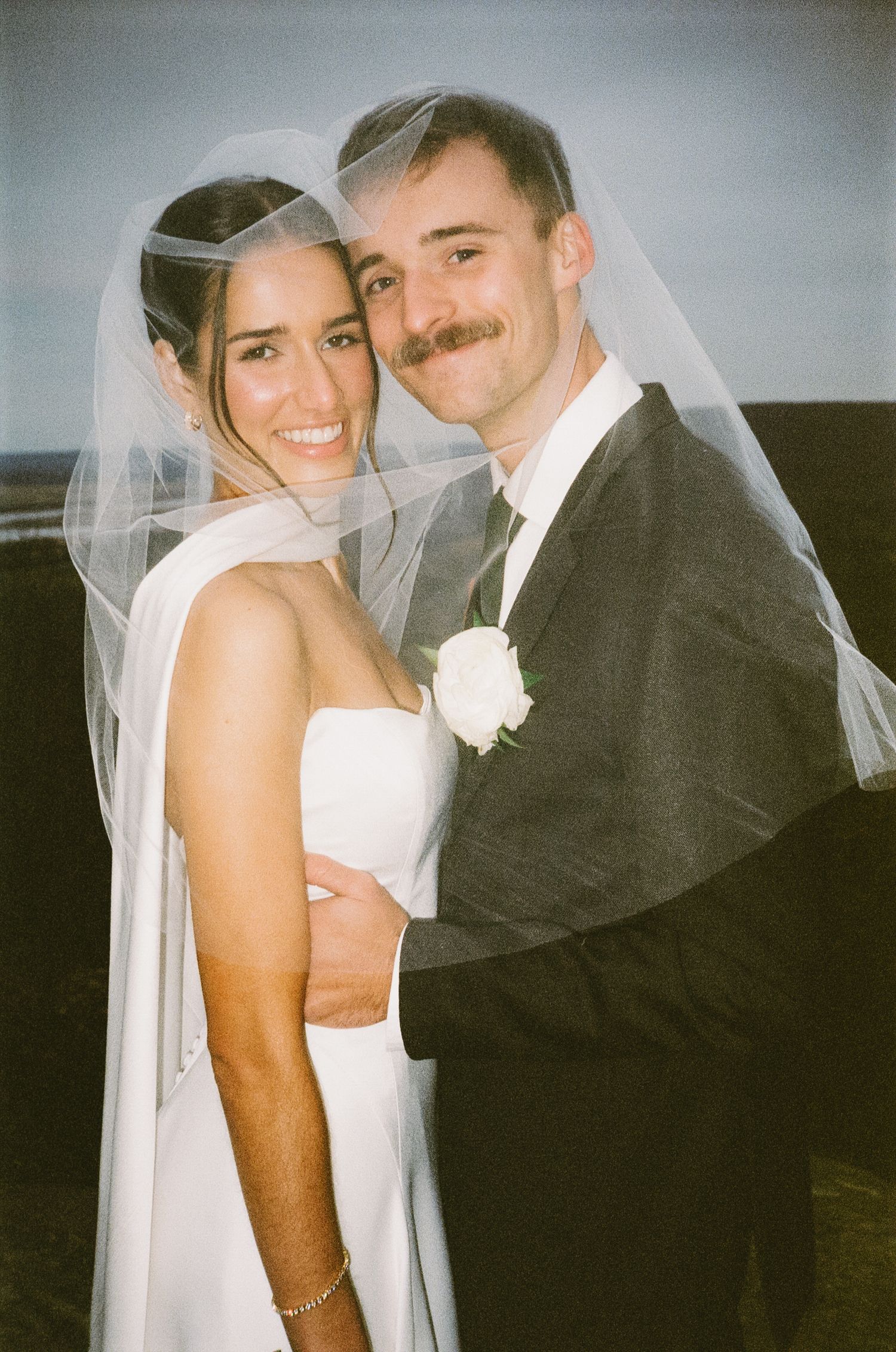 A romantic black and white wedding portrait of newlyweds sharing an intimate moment.