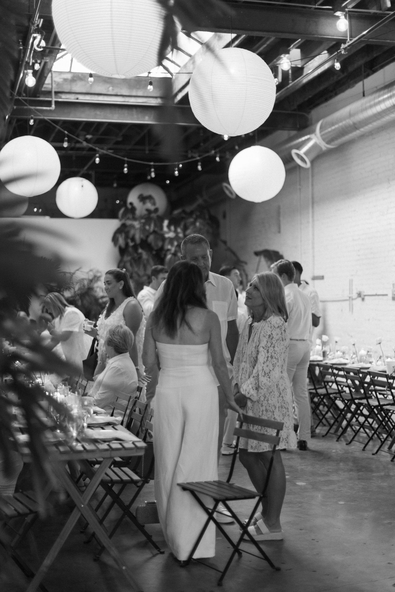 Wedding venue interior with paper lanterns and folding chairs arranged for ceremony.
