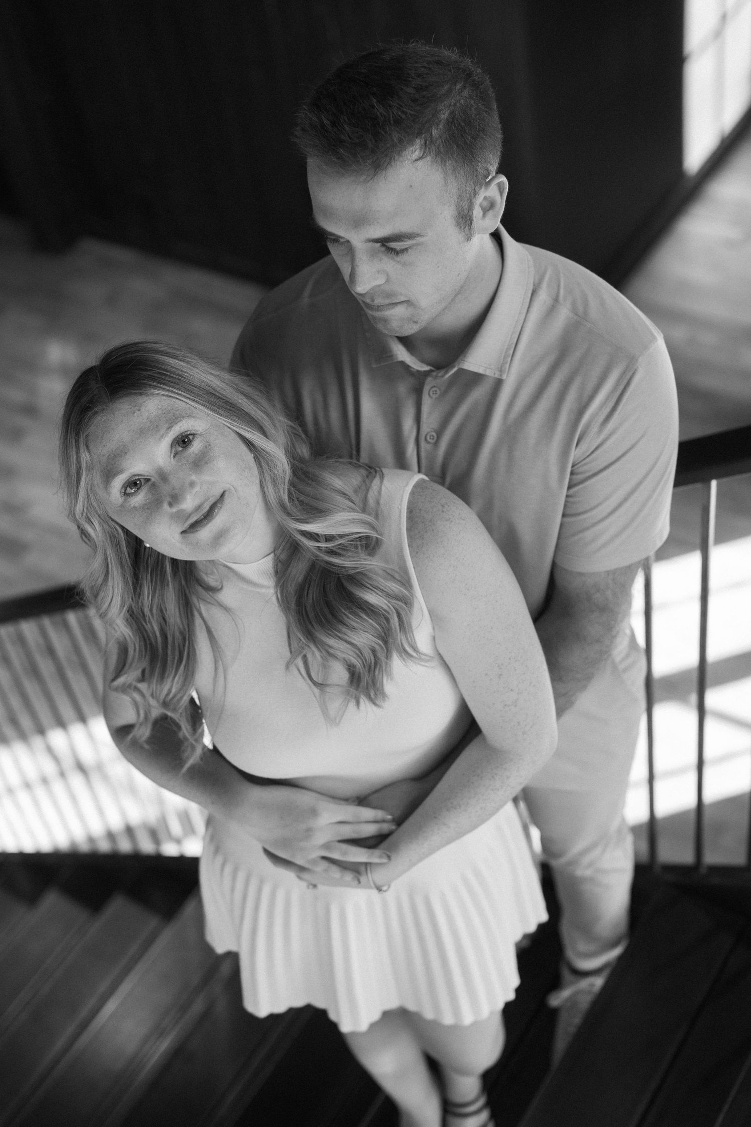 A romantic black and white photo series showing a couple dancing together indoors with dramatic window lighting.