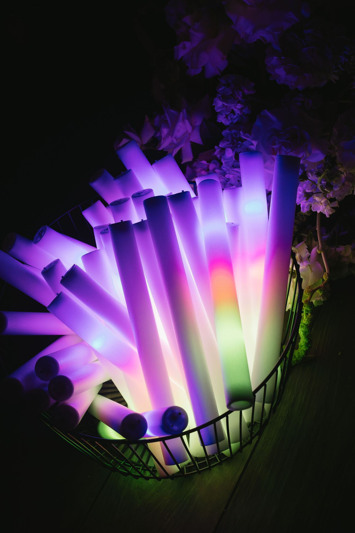 Colorful illuminated LED light tubes creating a dramatic purple and pink display in darkness.