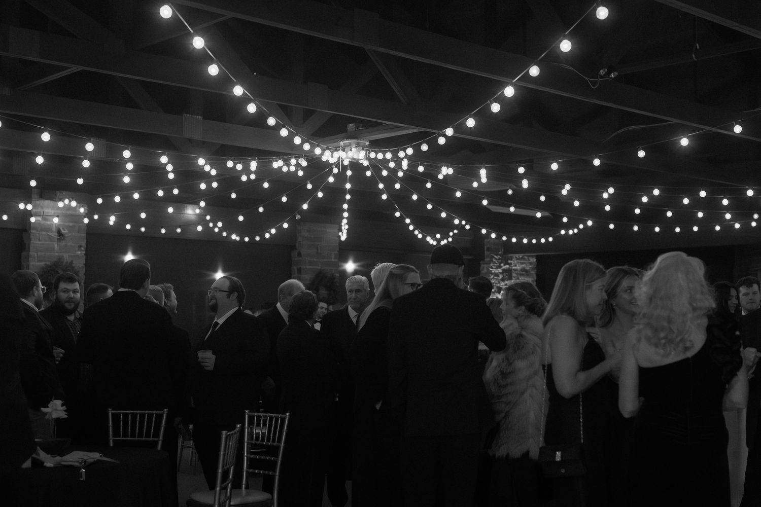 String lights illuminate a dark reception venue creating a romantic ambiance.