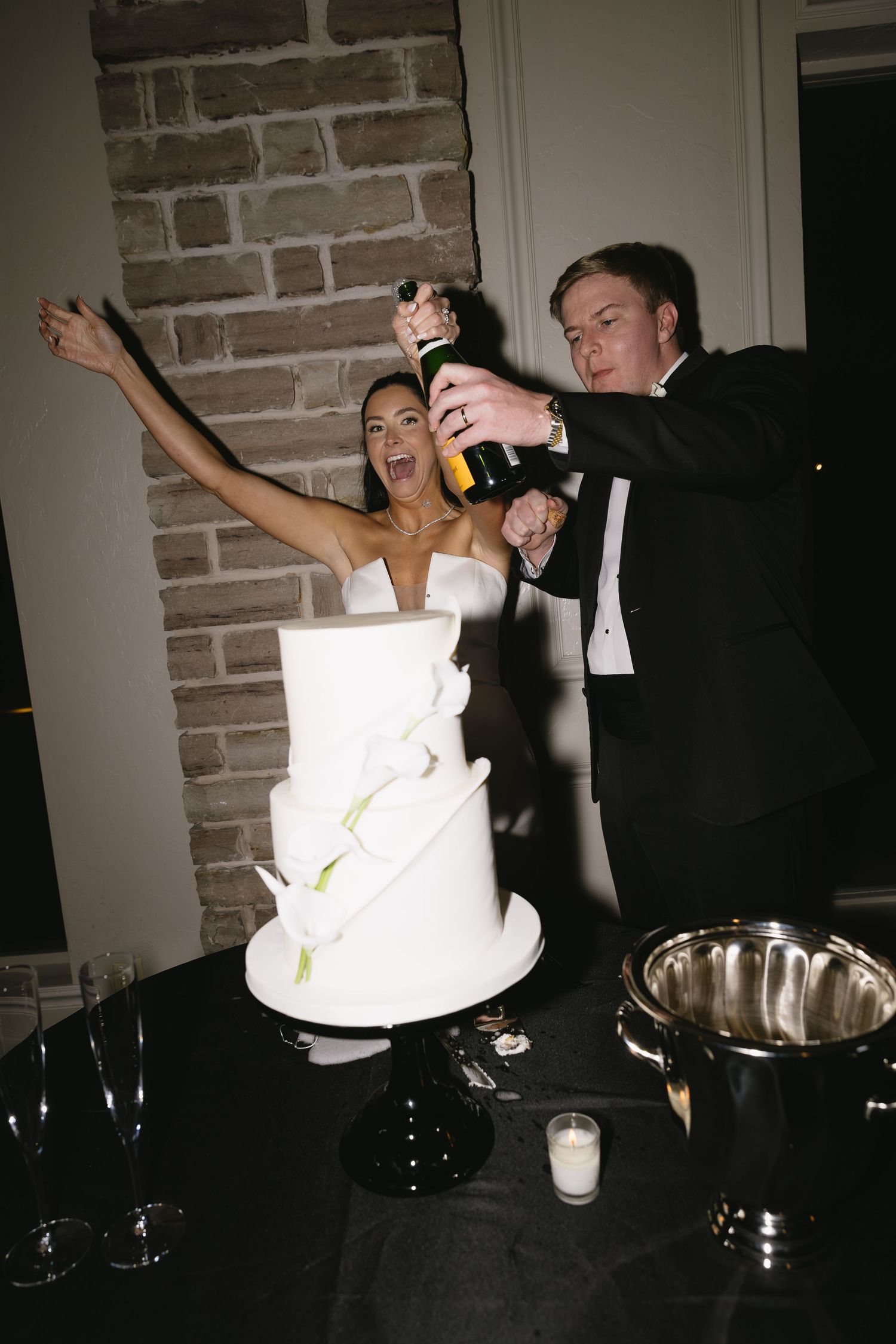 Sequence showing couple cutting and playfully sharing wedding cake in dimly lit room.