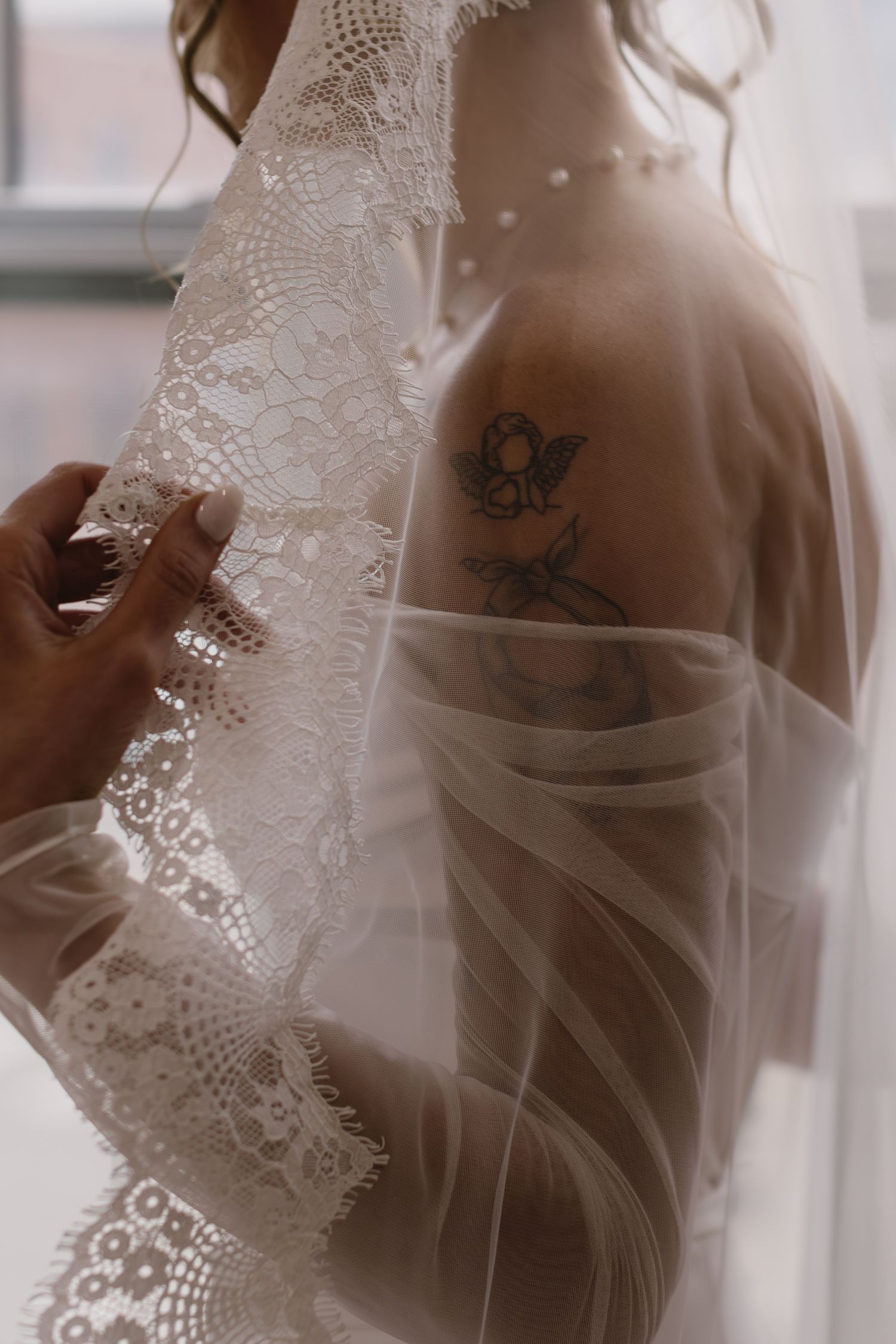 Delicate white lace veil creates soft shadows and romantic silhouettes in an ethereal bridal boudoir photoshoot.