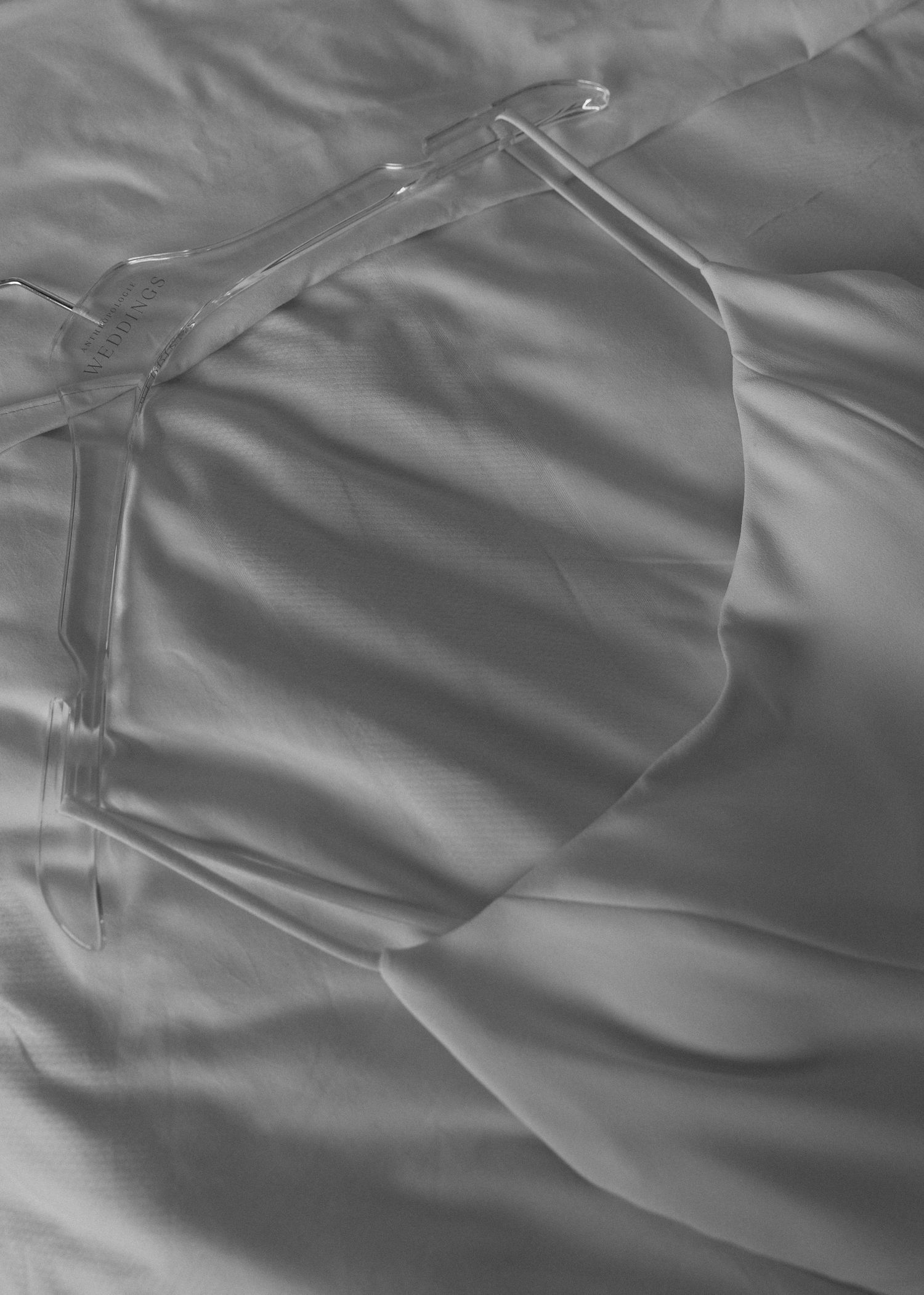 Close-up details of elegant wedding dress fabric with delicate pleating and draping in soft lighting.
