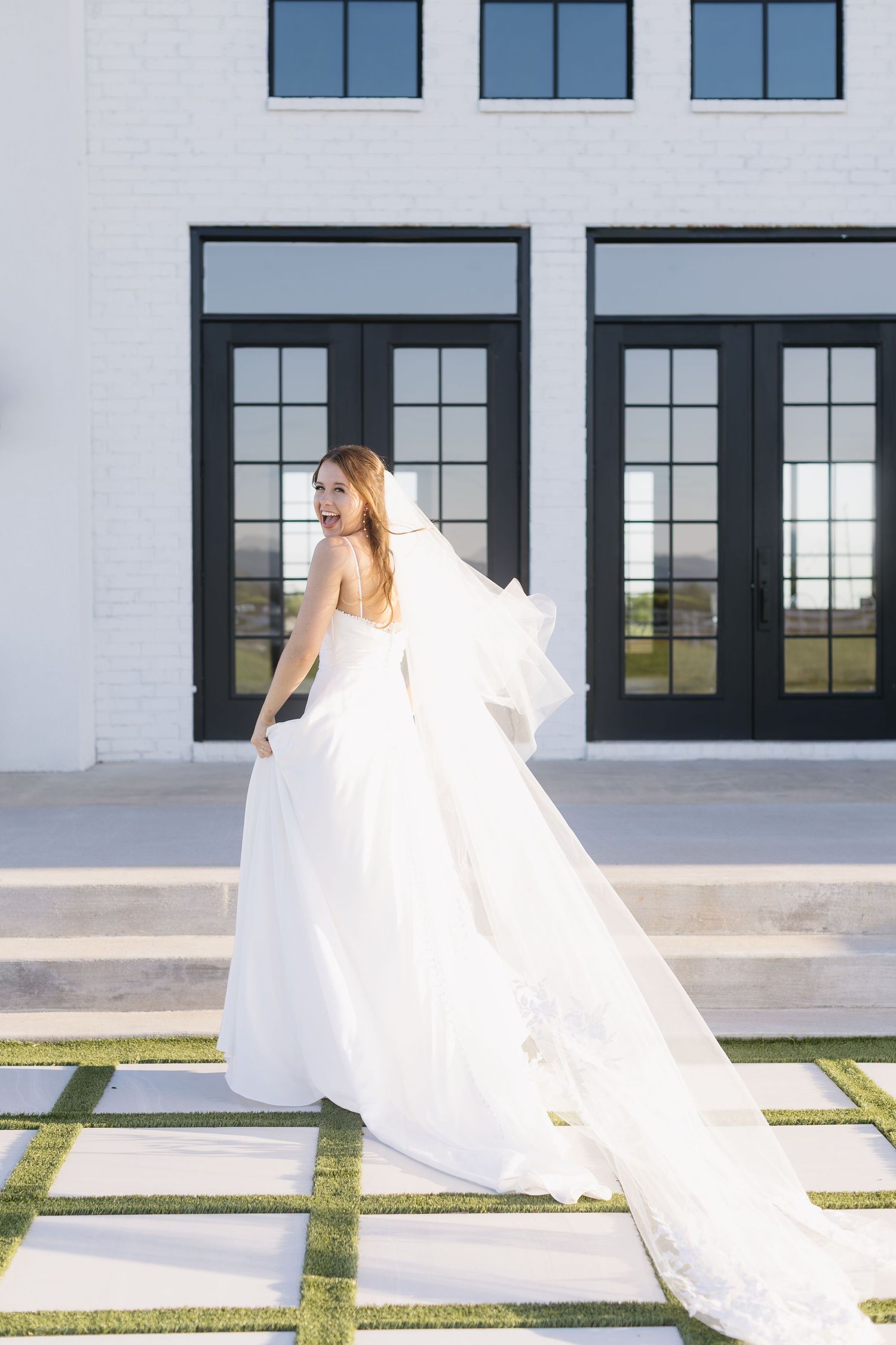 A series of photos capturing a bride's white veil flowing gracefully in front of a contemporary white building.