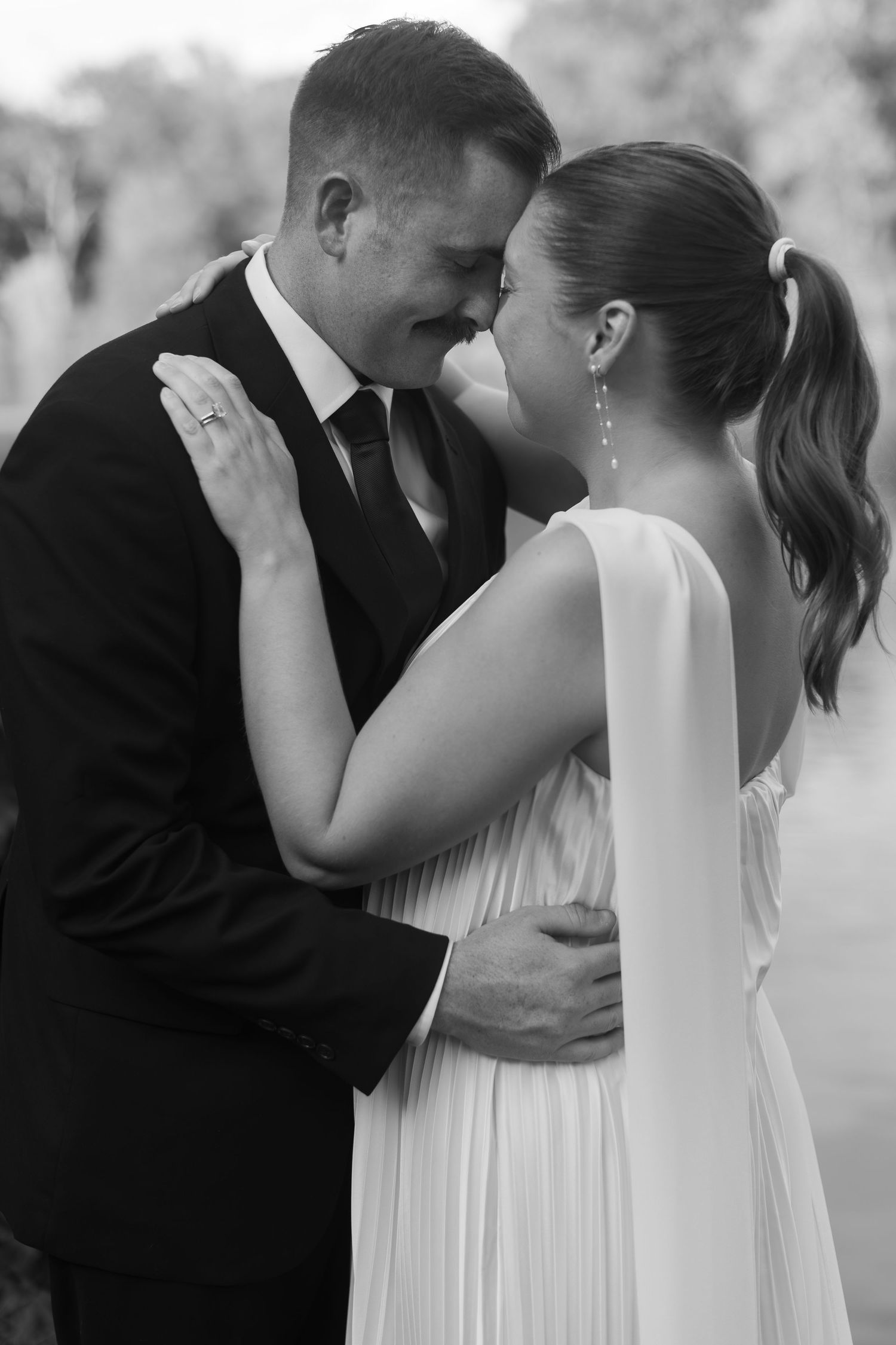 Black and white series of romantic intimate moments between newlyweds in formal wedding attire.