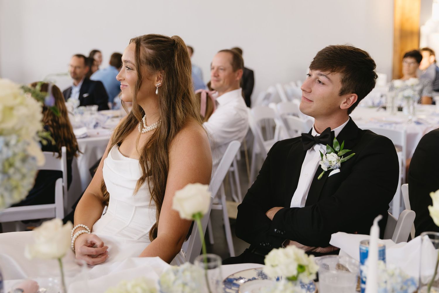 Wedding reception scene with formal table settings and decorations.