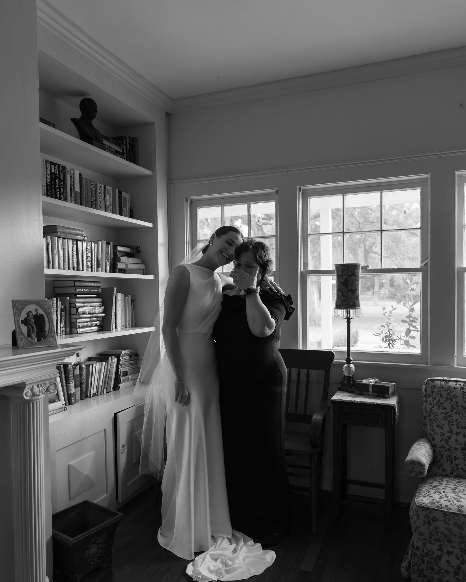 Wedding party preparations in a bright room with a wedding dress displayed and formal attire.