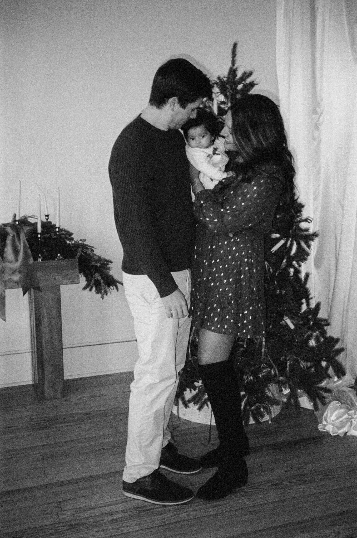 A black and white photo series showing a couple dancing together in a romantic sequence of dance moves on a wooden floor.